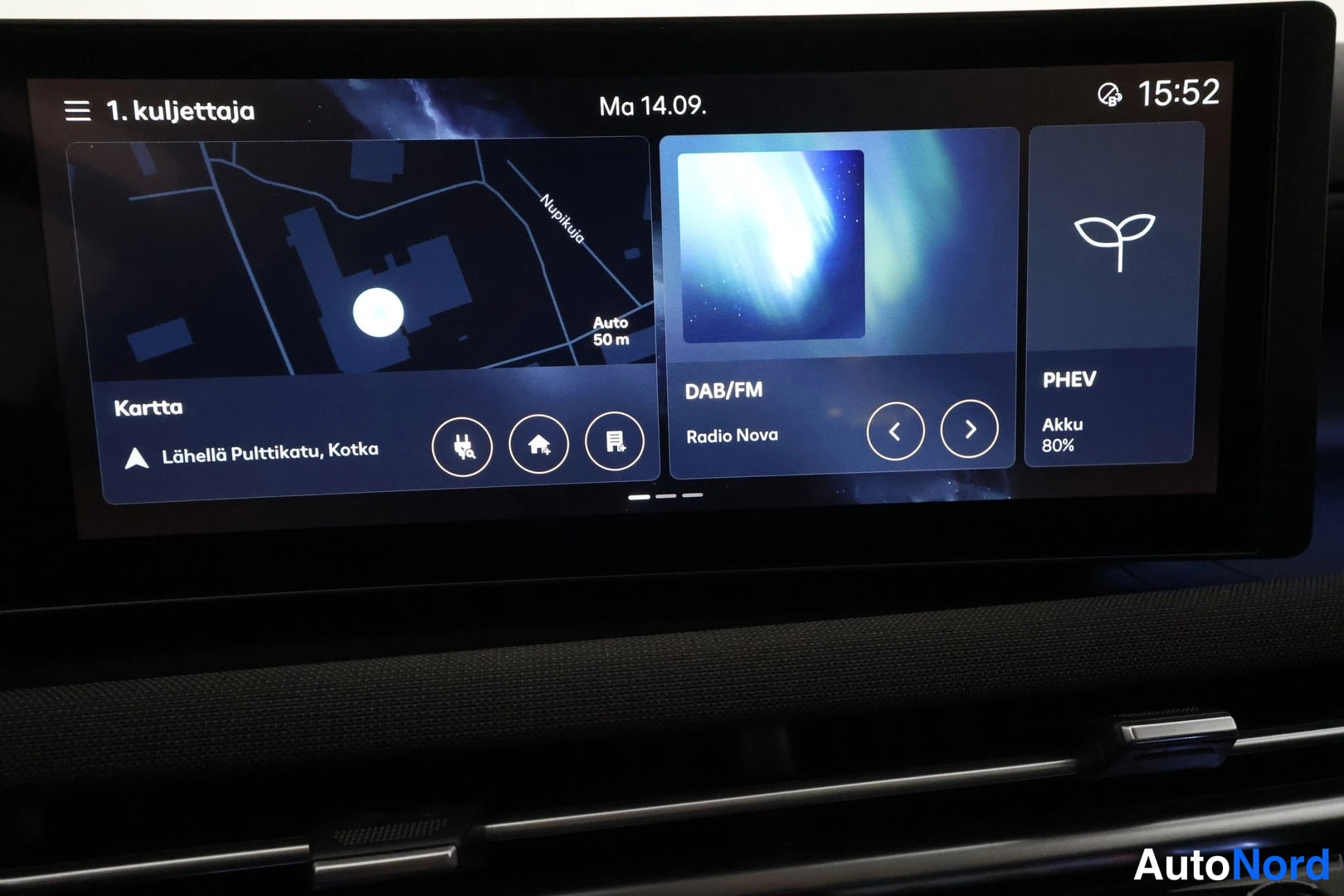 Muu: Uloskäytävässä oleva infotainment-näyttö näyttää karttanäkymän (Lähellä Pulttikatu, Kotka), DAB/FM-radion Radio Nova ja PHEV-tilan akkuvarauksen 80 %.