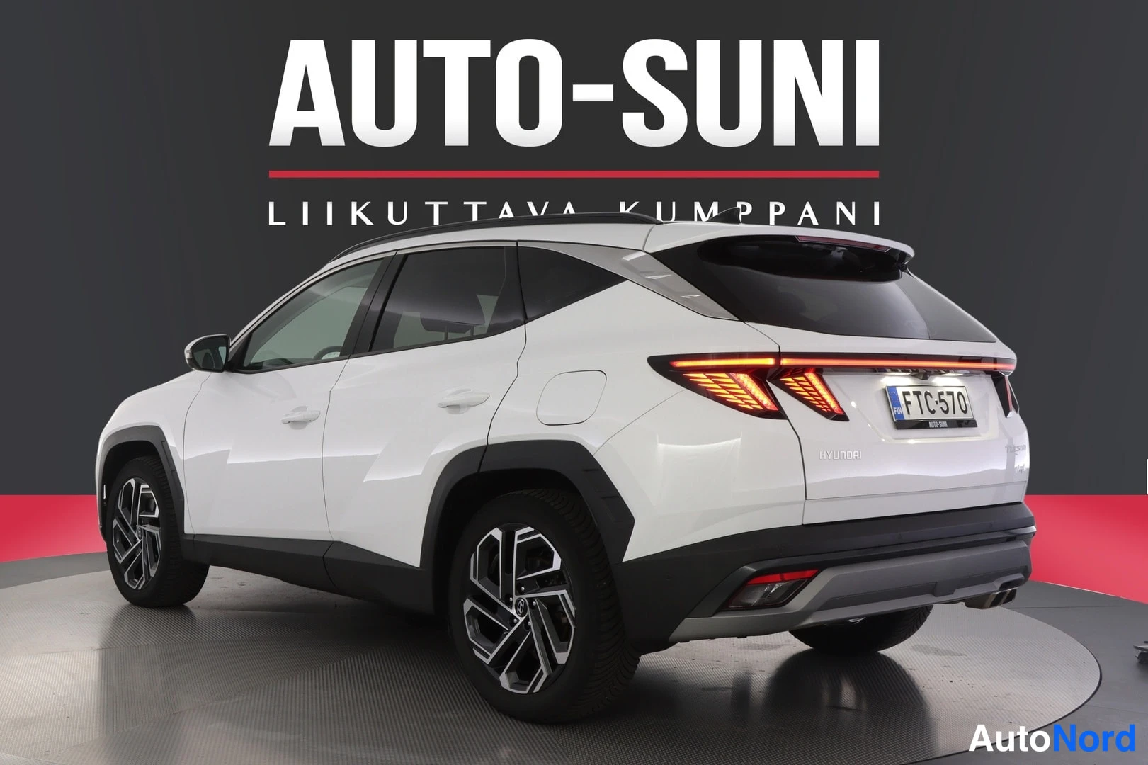 Takaviisto: Hyundai Tucson, valkoinen auto takakulmasta kuvattuna, näkyvät takavalot, aukko ja rekisterikilpi, studiotausta