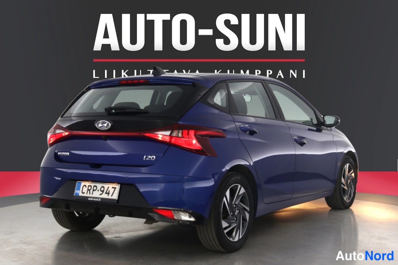 Takaviisto: Sininen Hyundai i20 -henkilöauto takaa ja sivulta kuvattuna studio-olosuhteissa.