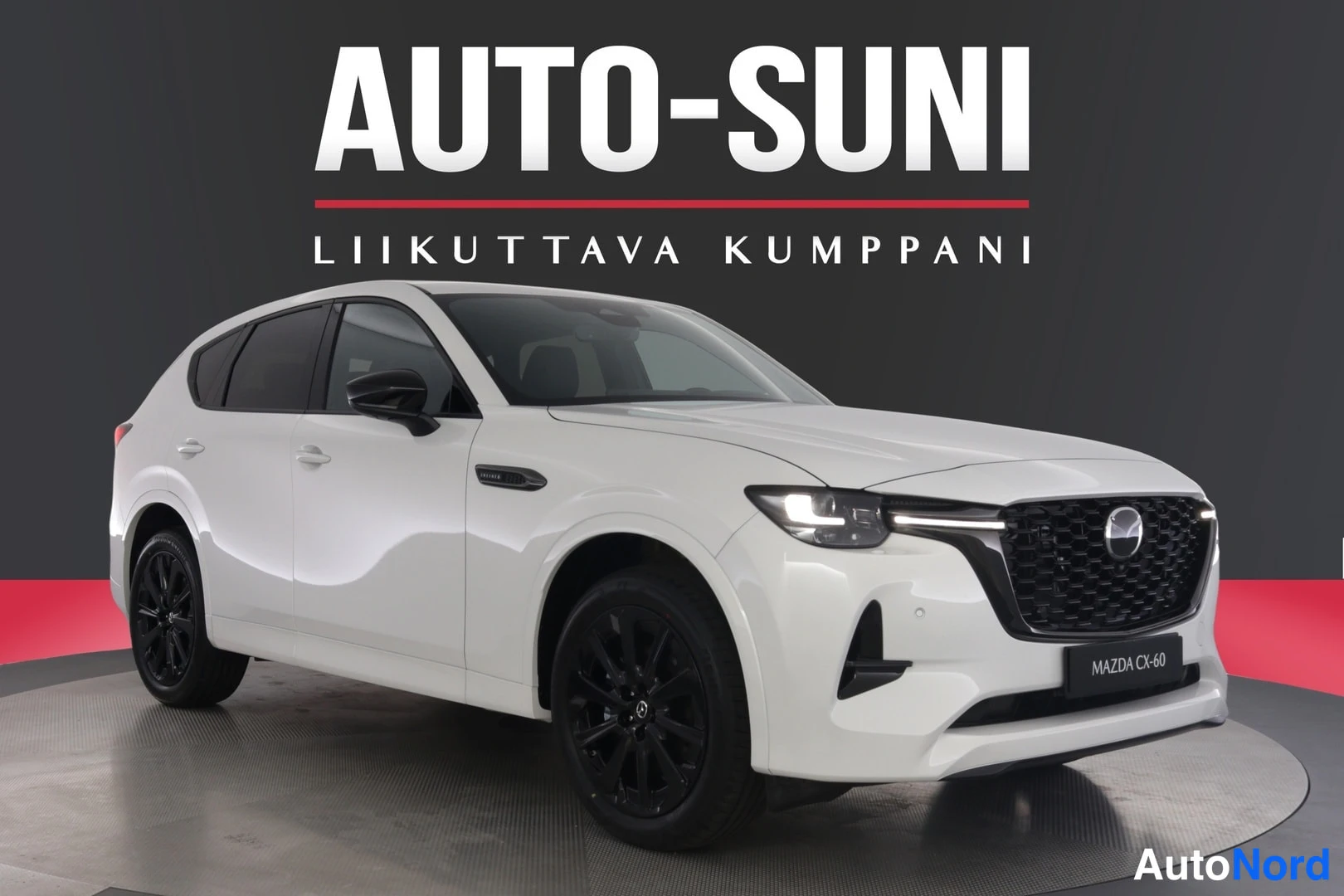 Etuviisto, nokka oikealle: Valkoinen Mazda CX-60 kulmassa kuvattuna, etusäleikkö ja mustat vanteet näkyvissä.