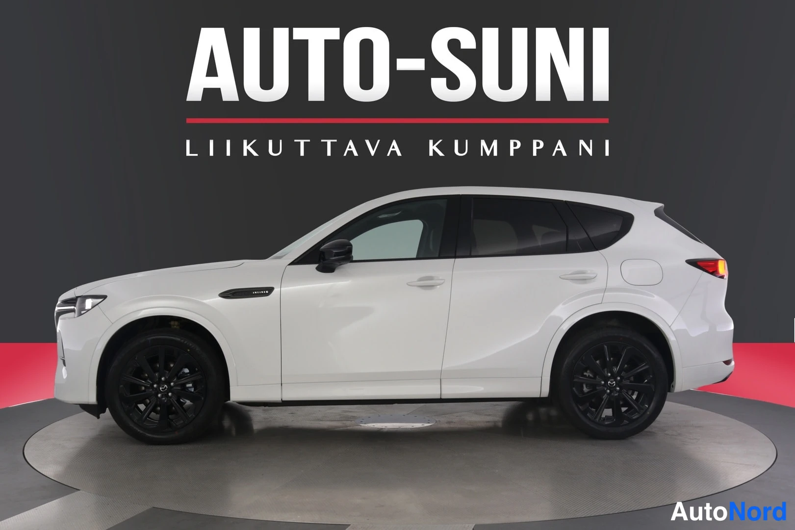 Sivulta: Valkoisen MAZDA-nimikilpiauton sivukuva studio-olosuhteissa; mustat vanteet, taustalla AUTO-SUNI-logo.