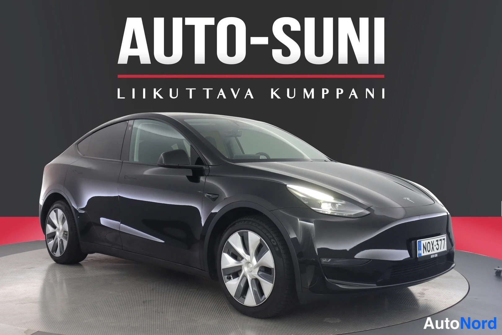 Etuviisto, nokka oikealle: Musta Tesla Model Y etuviistosta oikealta, rekisteritunnus, Auto-Sunin studioimga.