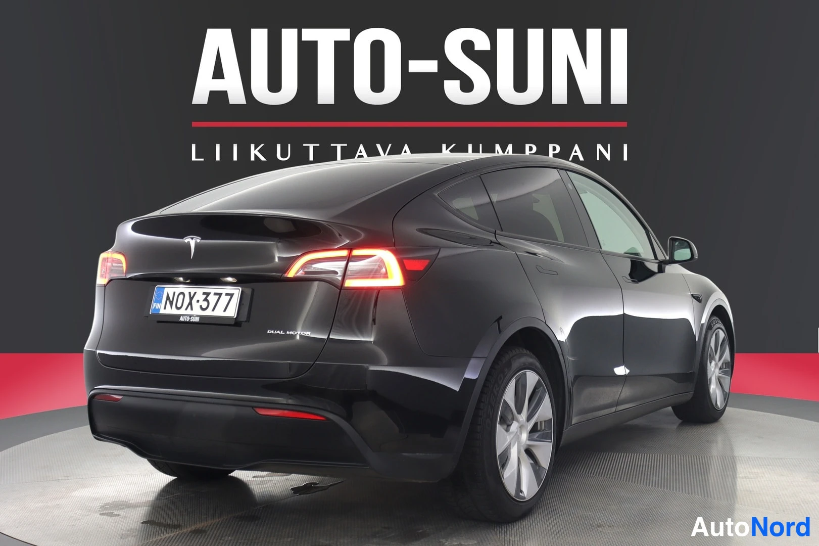 Takaviisto: Musta Tesla Model Y takaviistosta, Dual Motor-teksti takaluukussa, rekisteritunnus.