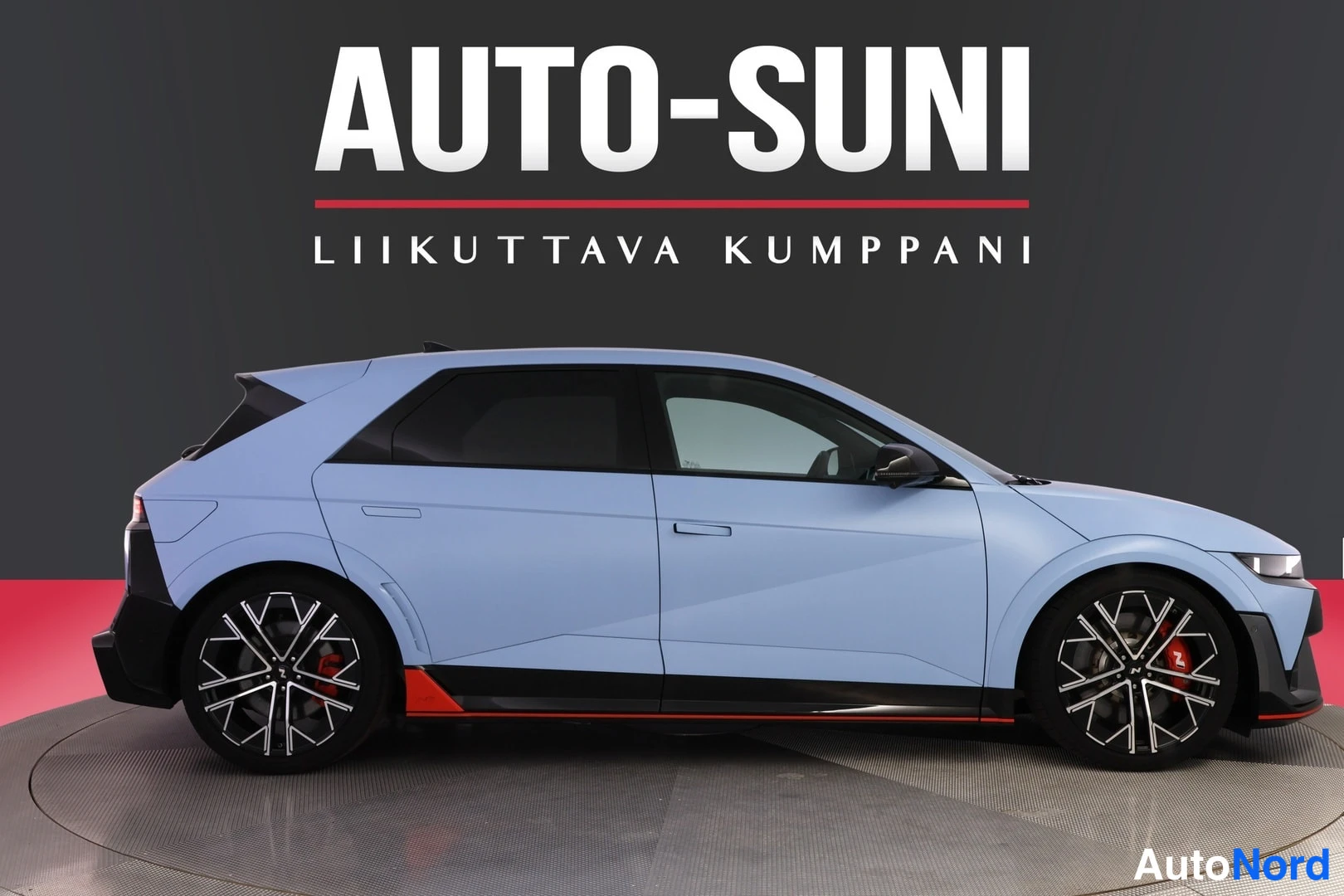 Sivulta: Auton sivukuva: vaaleansininen viistoperäinen henkilöauto tummalta taustalta.