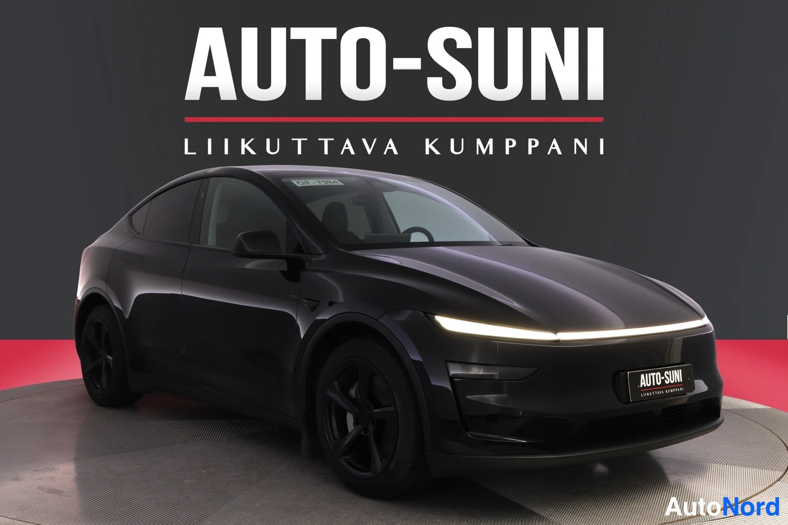 Etuviisto, nokka oikealle: Mustan teslamallin etunäkymä vinosti oikealta, edessä valaistu_LIGHT-keilanäköinen etulamppuvall