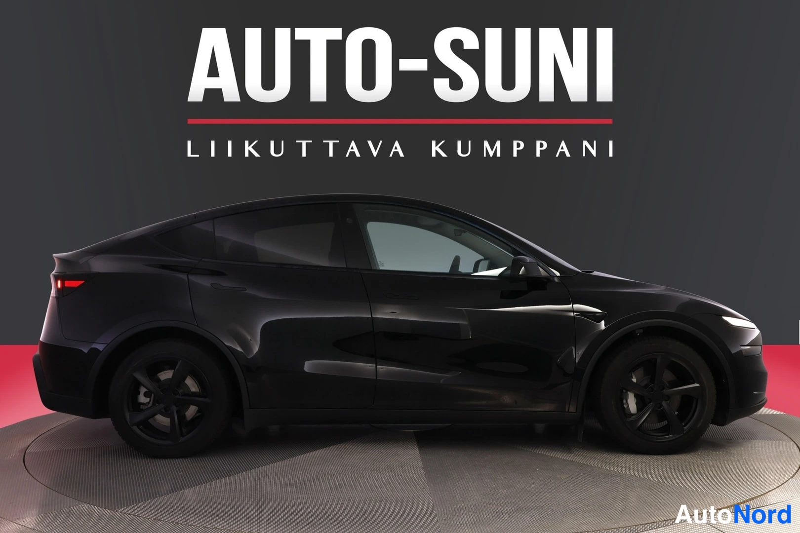 Sivulta: Mustan auton sivuprofiili nähtynä vasemmalta, tummat vanteet ja tunnelma studioasennossa