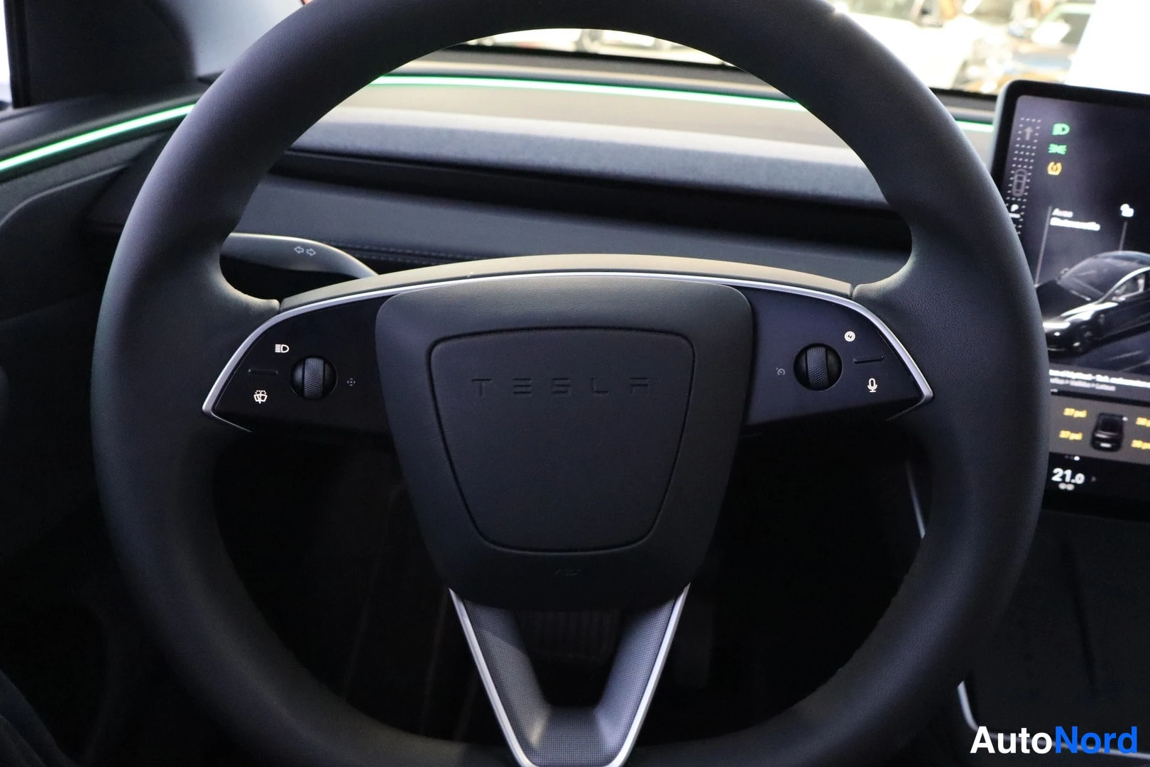 Muu: Tesla-merkillä varustettu ohjauspyörä ja sen takana osa kojelaudan näytöstä.