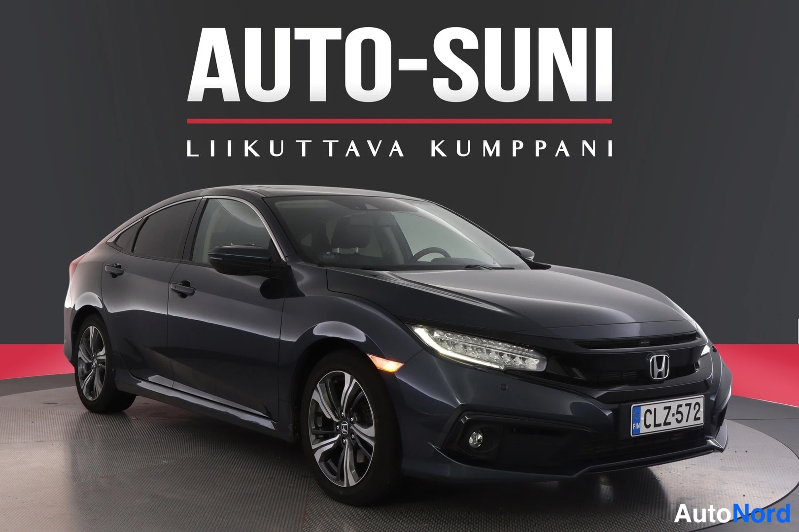 Etuviisto, nokka oikealle: Auton keula ja vasen sivu kuvattuna vinosti, tummansininen Honda sedan näyttötilassa.