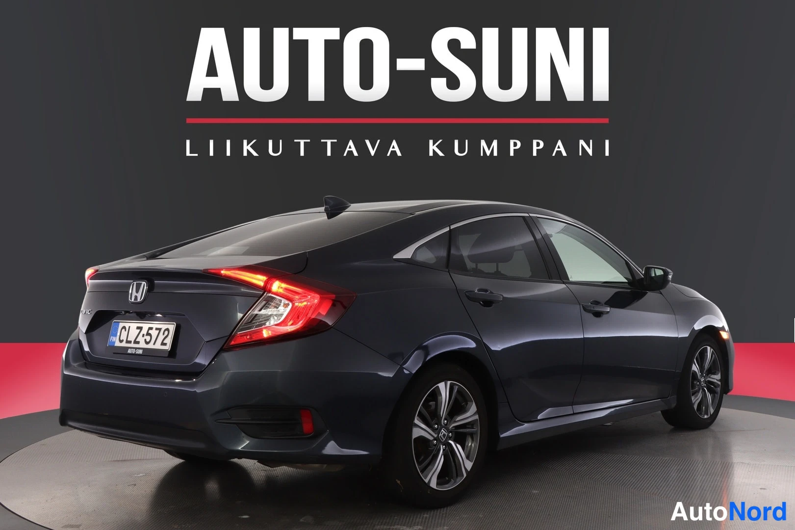 Takaviisto: Honda Civic -sedanin takakulma, tummansininen koripinta, rekisterikilpi ja Honda-merkki takaluukussa.