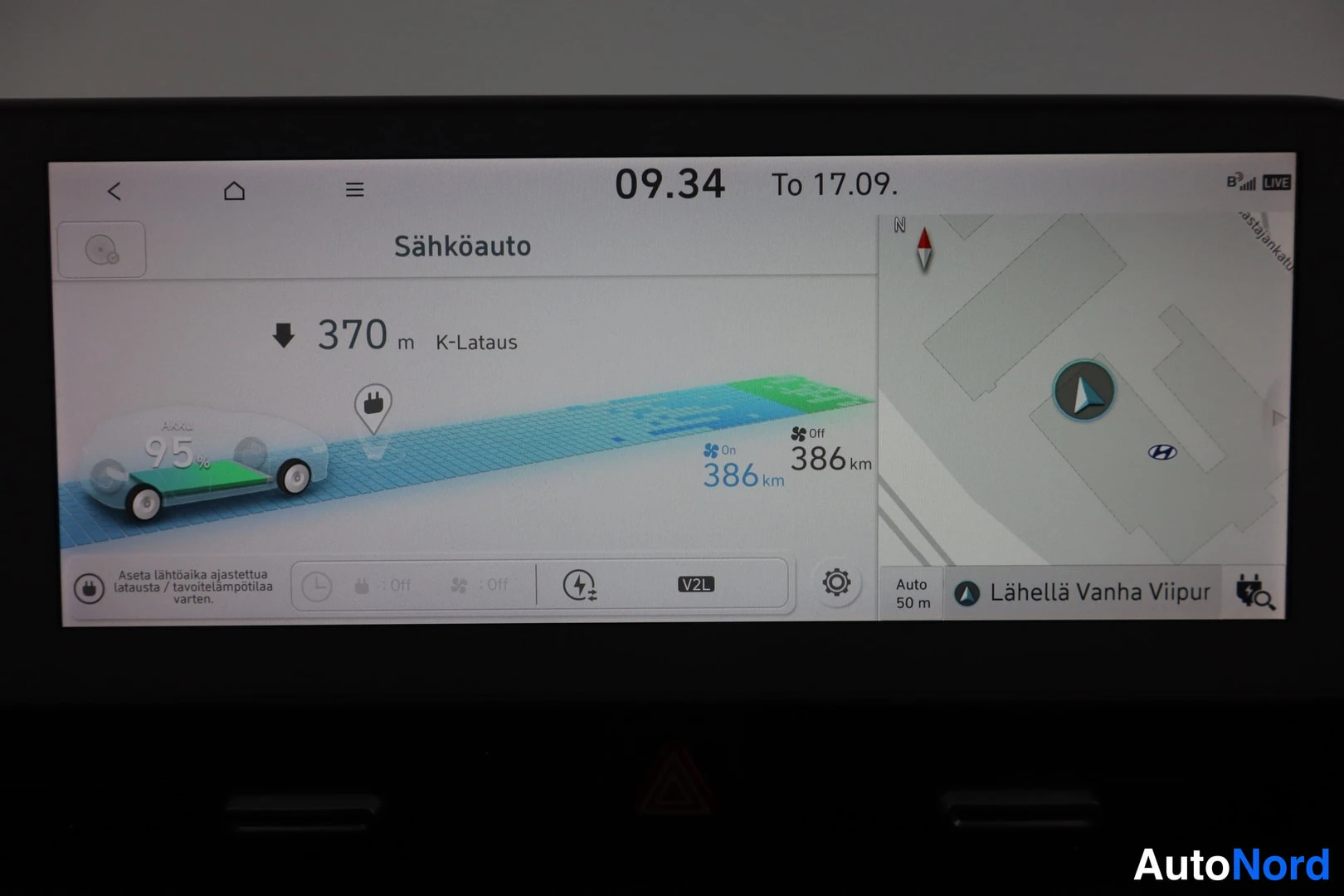 Yksityiskohta: Auton näytöllä näkyy sähköauton lataustila 95 % (386 km), V2L-merkintä ja kartta.