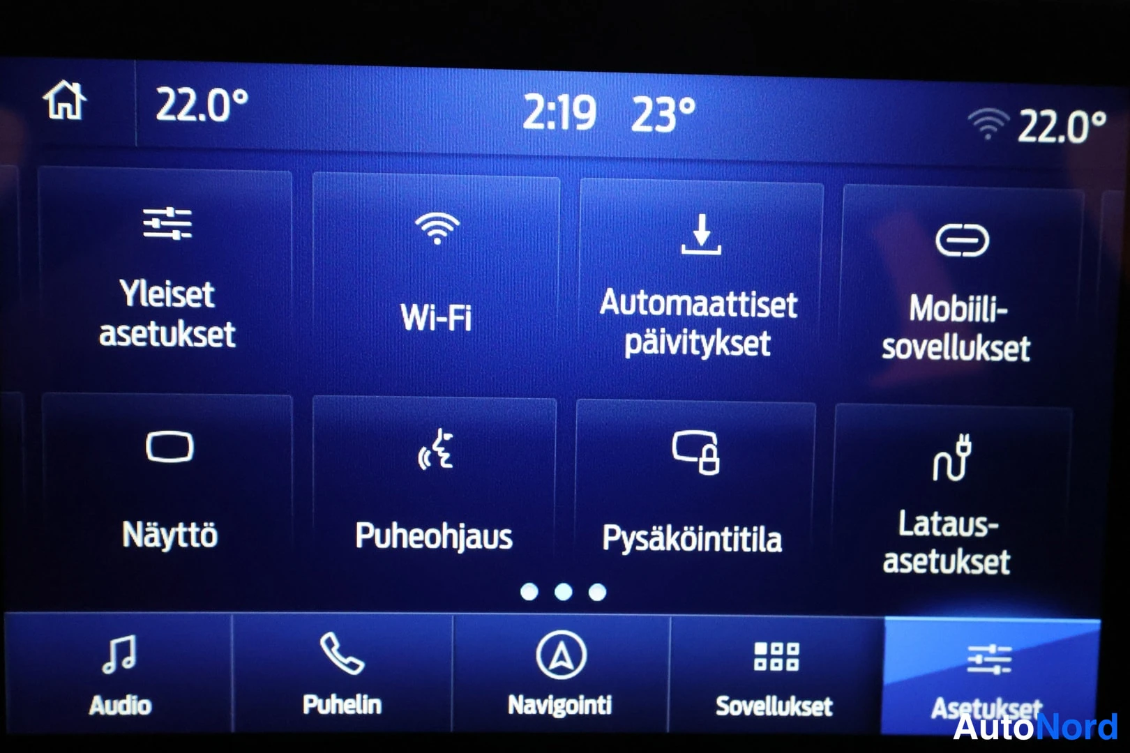 Yksityiskohta: Asetusvalikon ruutu: Yleiset asetukset, Wi-Fi, Automaattiset päivitykset, Mobiilisovellukset, Näyttö, Puheohjaus, Pysäköintitila ja Latausasetukset.
