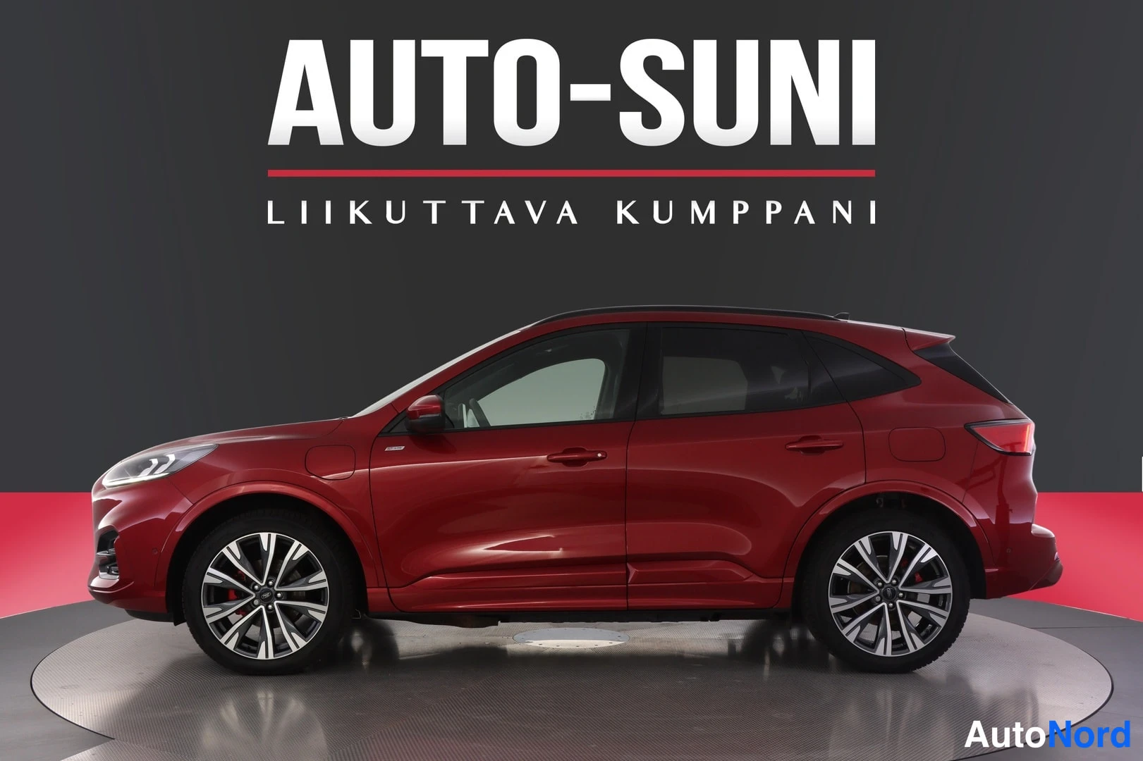 Sivulta: Punainen Ford Kuga -maasturi sivusta kuvattuna studioalueella, Auto-Suni-logo taustalla.