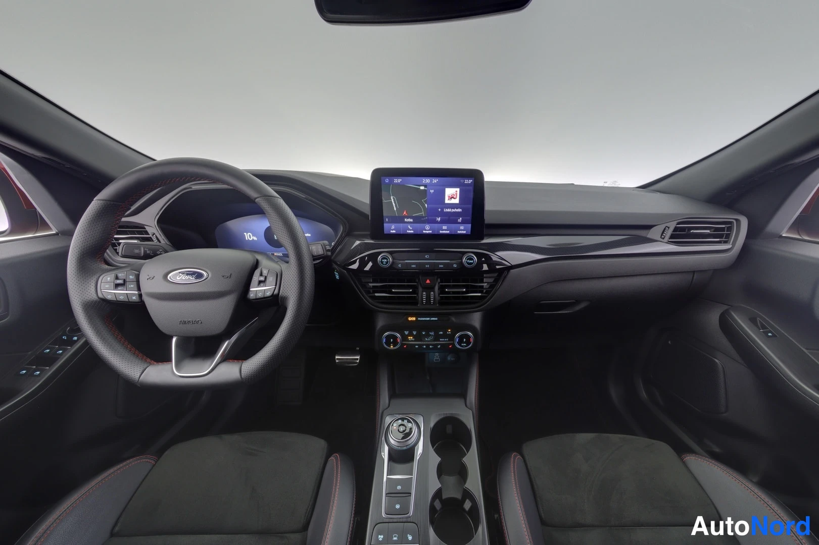 Yksityiskohta: Ford Kuga:n kojetaulu ja ohjaamotila: monitoimiohjauspyörä, medianäyttö, ilmastointipainikkeet ja vaihteenvalitsin.