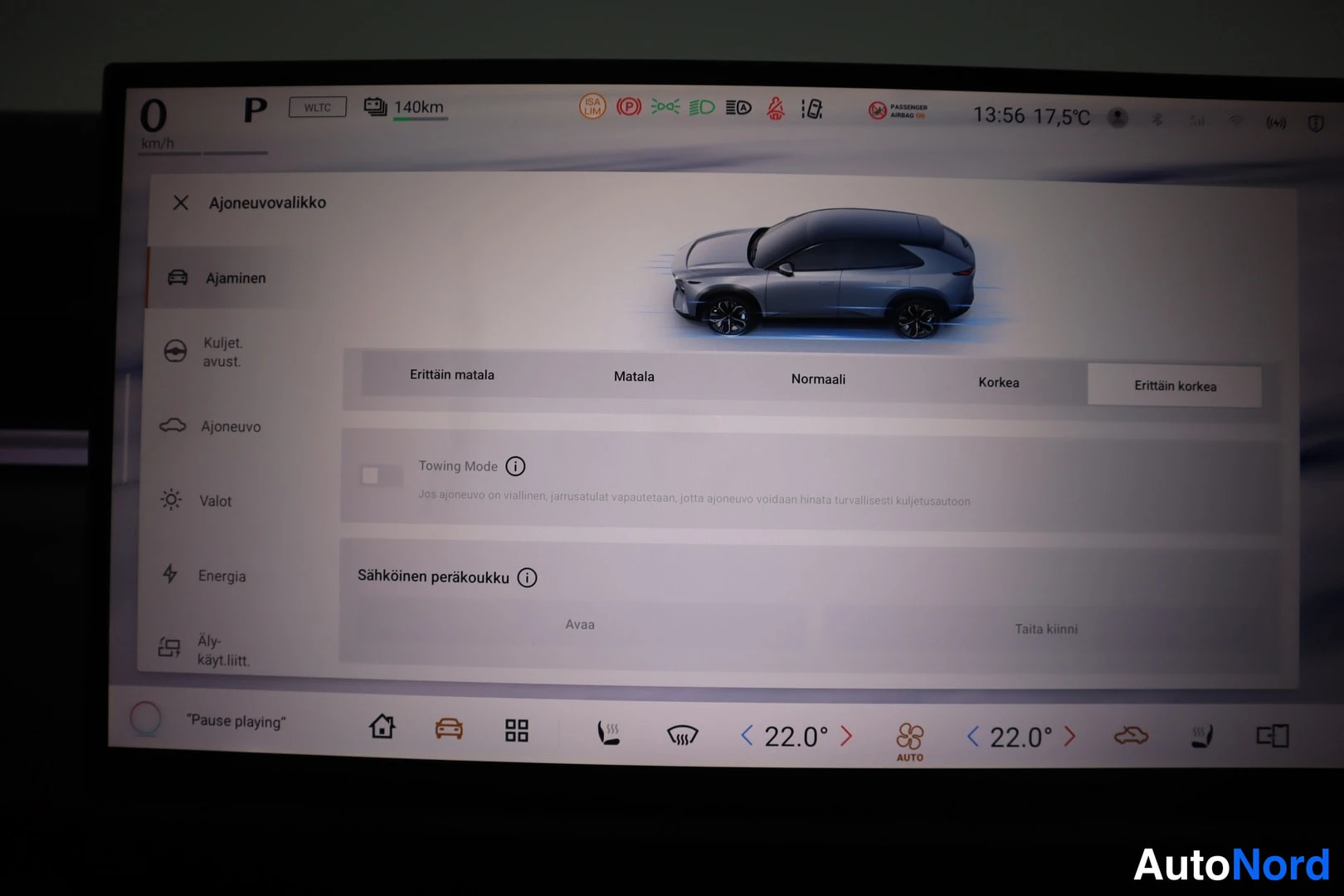 Yksityiskohta: Auton infotainment-näyttö ajoneuvovalikko avattuna: ajokorkeuden valinta (Erittäin matala – Erittäin korkea), Towing Mode ja sähköisen peräkoukun avaus- ja tait