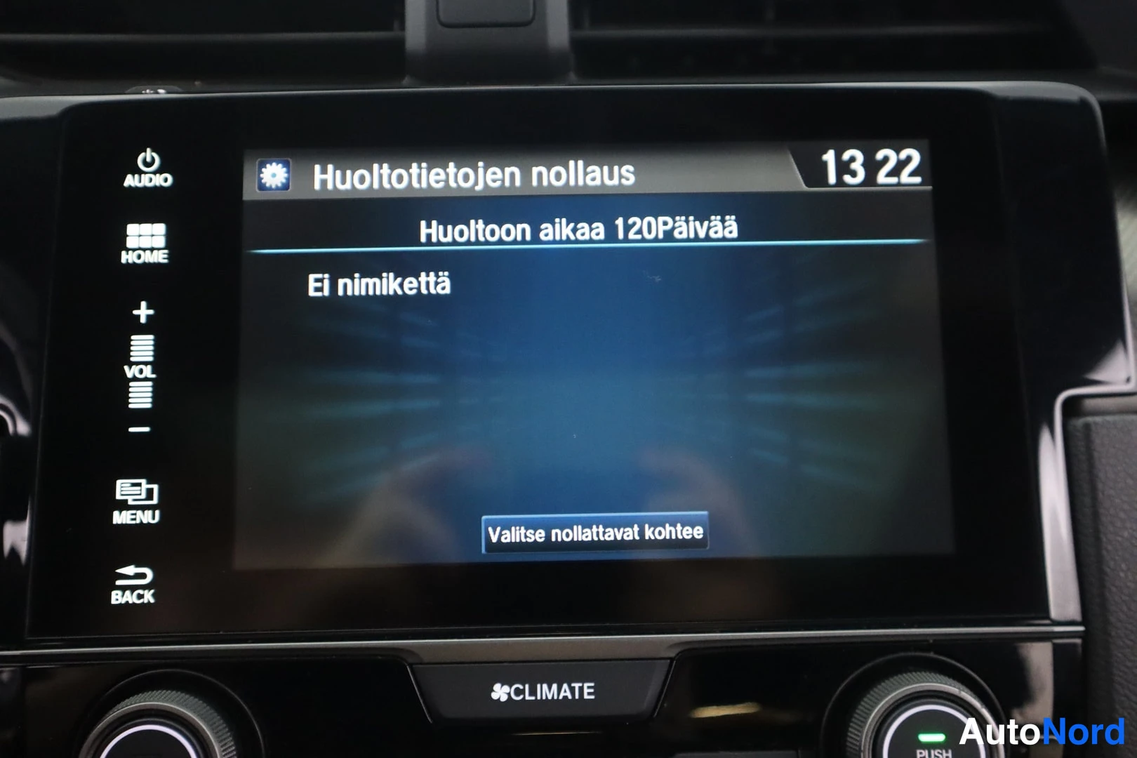 Yksityiskohta: Keskinäisnäytöllä huoltotietojen nollausvalikko (13 22, Huoltoon aikaa 120Päivää), alla CLIMATE-teksti ja ilmastoinnin nupit.