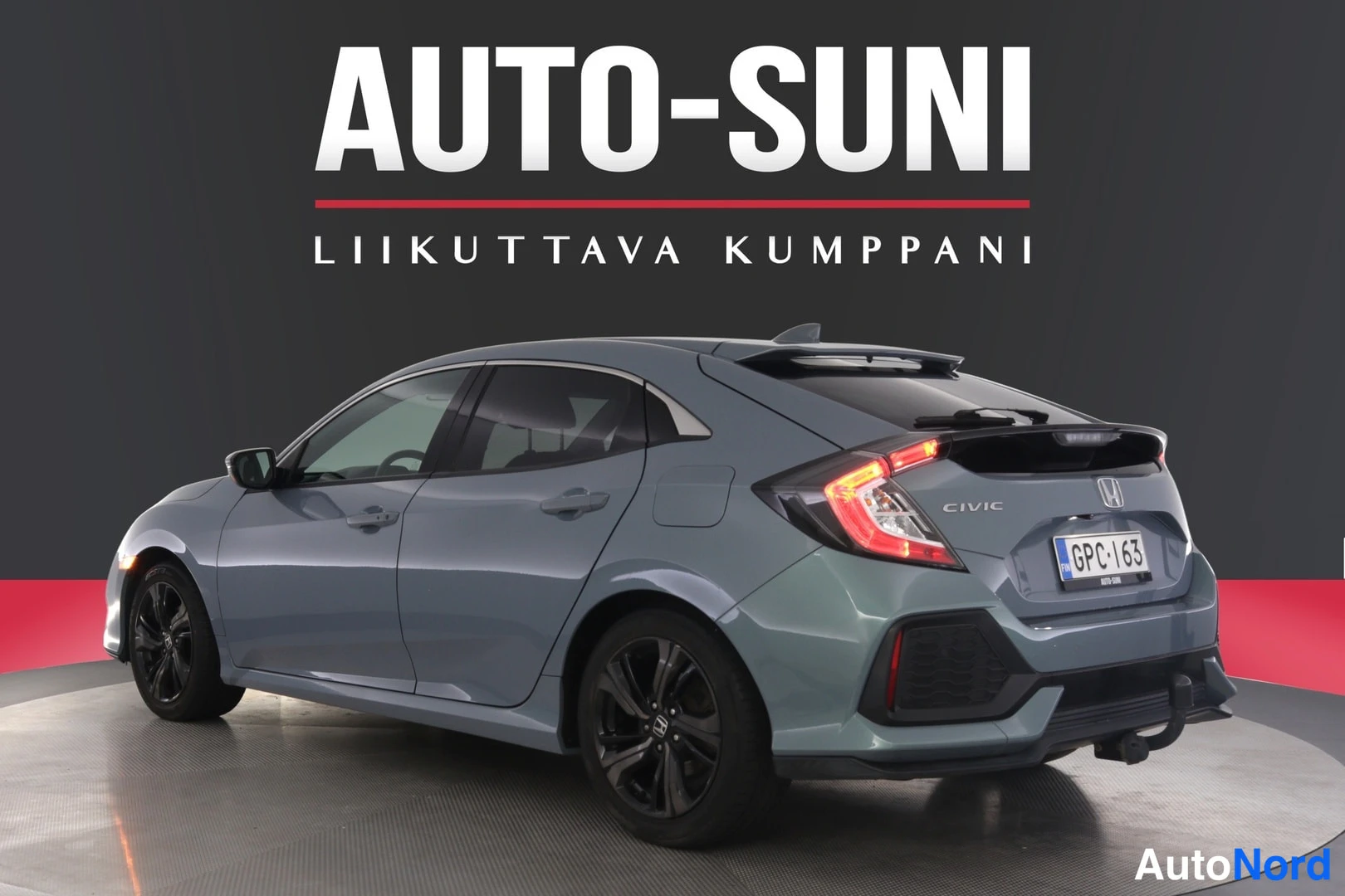 Takaviisto: Harmaansininen Honda Civic viistoperä takakulmasta kuvattuna; CIVIC-teksti ja rekisterikilpi näkyvät takakannessa.