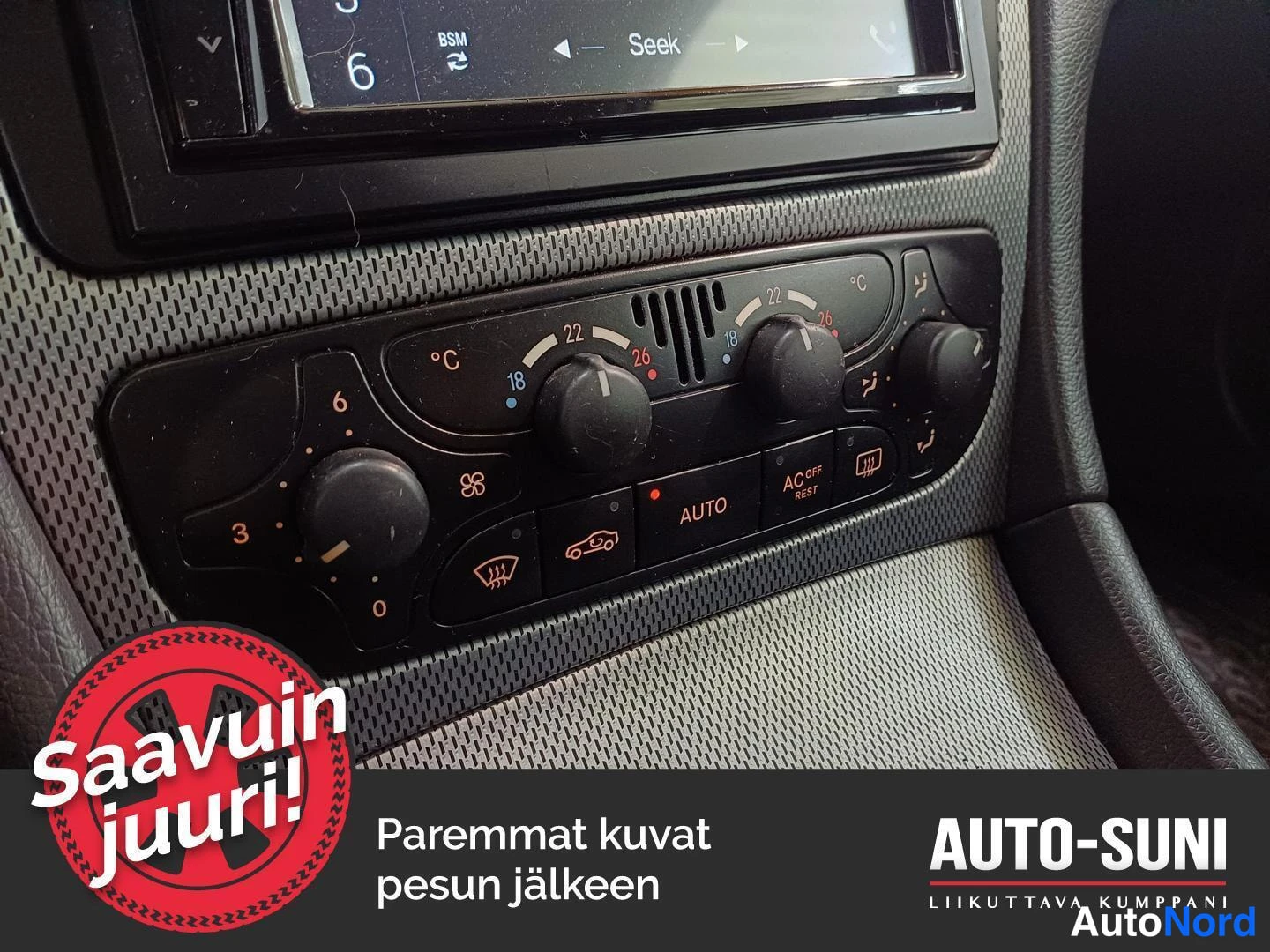 Ohjaamo: Detailed view of the manual climate control panel below the radio. It features three rotary knobs for temperature and fan settings, along with push-buttons for