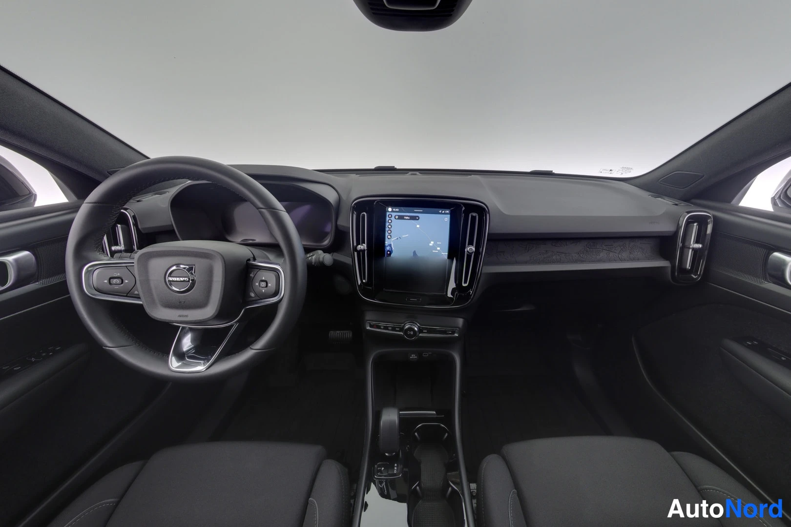 Muu: Ohjaamo etusivunalta: Volvo-ohjauspyora, keskikonsolin suuri kosketusnaytto ja tummat penkit.