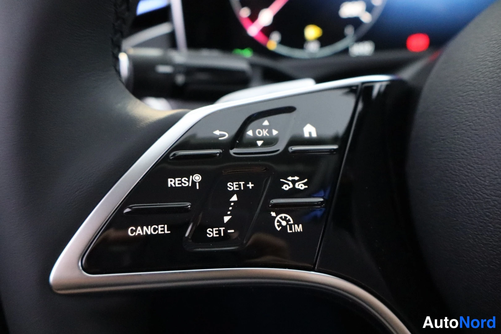 Sivulta: Close-up of Mercedes steering wheel control cluster with cruise control and speed limiter buttons
