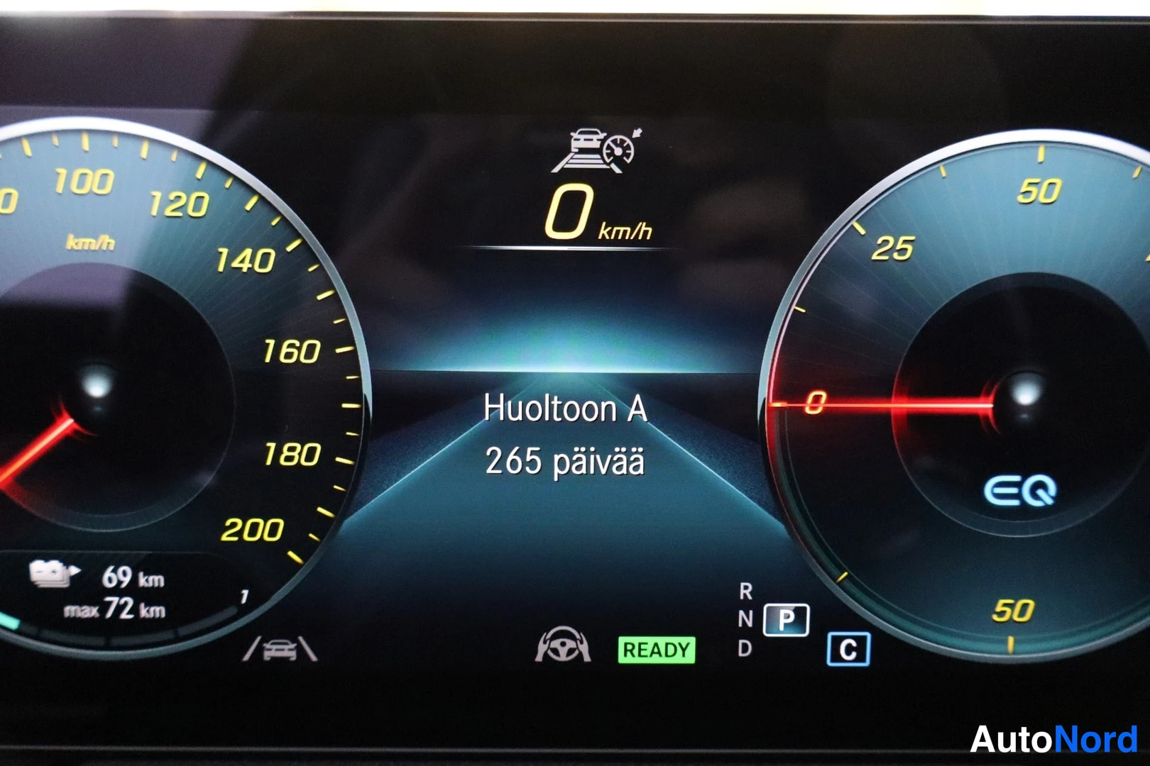 Muu: Digitaalinen instrumenttinäyttö: nopeus 0 km/h, vaihde P ja 'READY', ilmoitus 'Huoltoon A 265 päivää', aktiivinen kaista-avustaja ja 69 km matkan tiedot.