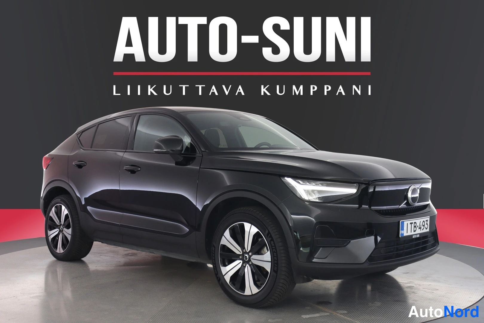 Edestä: Musta Volvo C40 etuviistossa studio­lavatustuksessa. Rekisterikilpi 1TB-493 näkyy etupuskurissa.