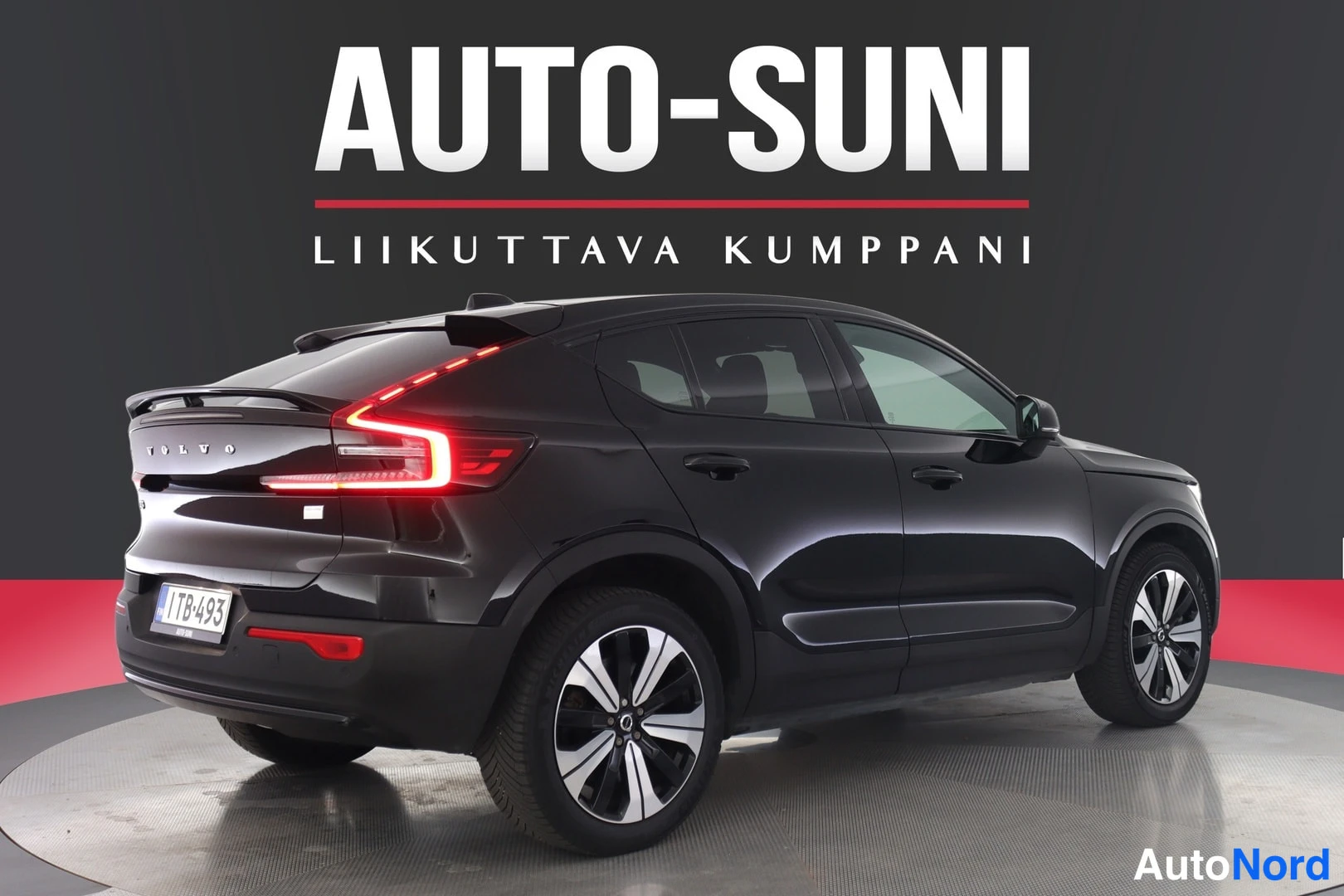Takaa: Musta Volvo C40 takaviistossa studio­lavatustuksessa. Volvo­teksti takaluukissa ja rekisterikilpi 1TB-493 näkyvät takapuskurissa.