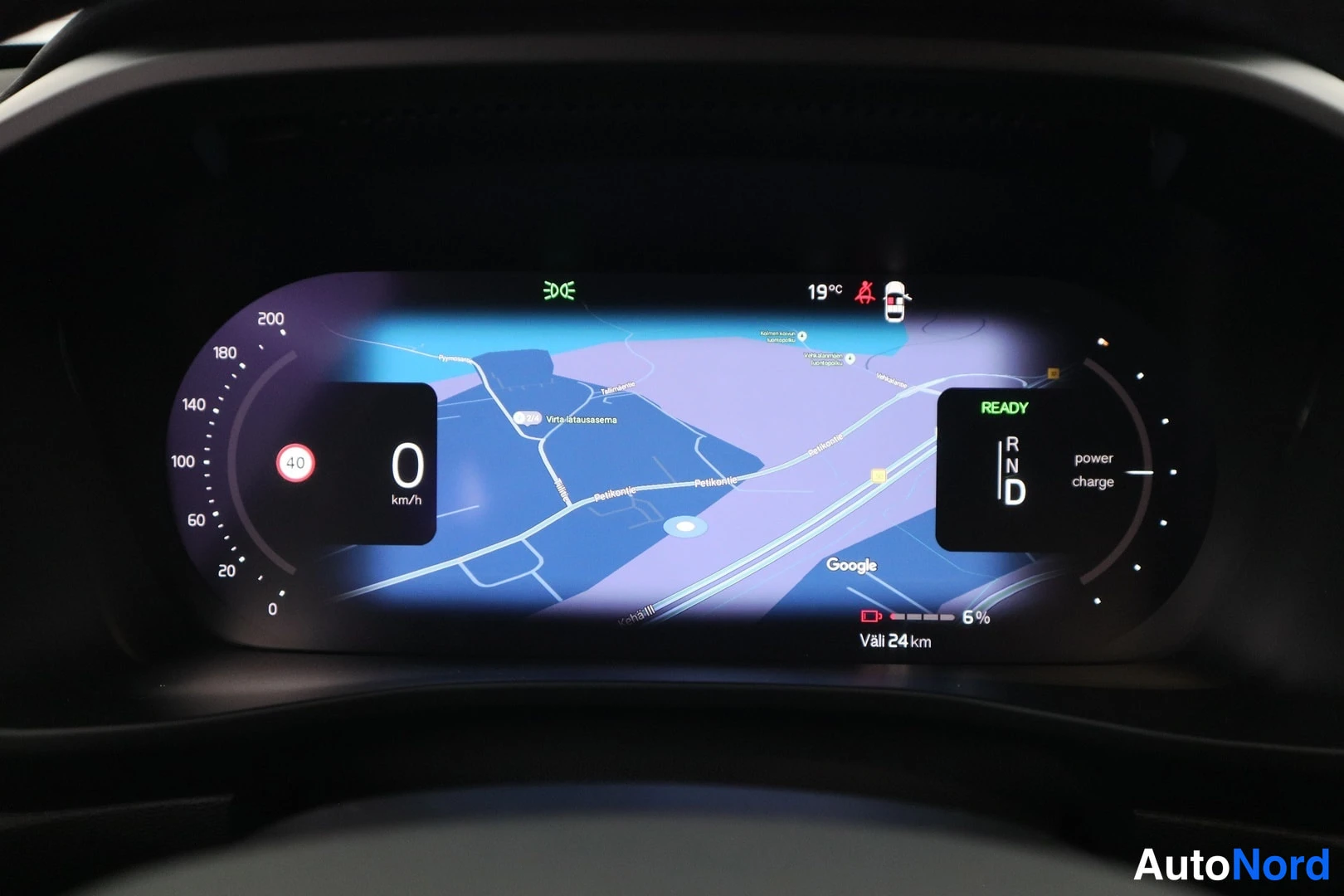 Muu: Volvo C40:n digitaalinen kojelauta näyttää kartan, READY-tilan, power charge -osoittimen, 0 km/h -nopeuden, 6 % lataustason ja 'Väli 24 km' -tiedon.