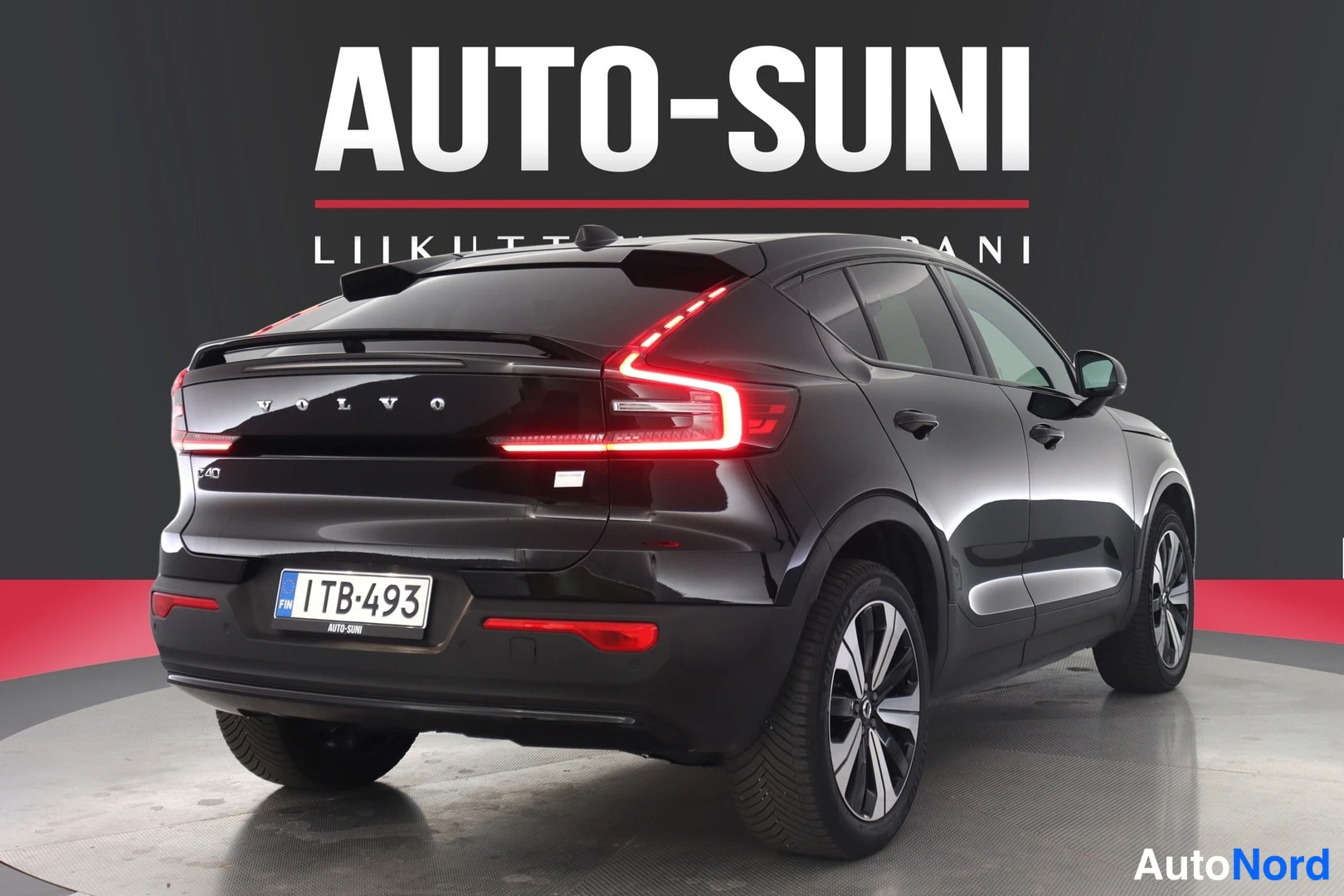 Takaa: Musta Volvo C40 suora­takaa studio­lavatustuksessa. C40­merkki, Volvo­teksti ja rekisterikilpi 1TB-493 näkyvät takaluukissa.