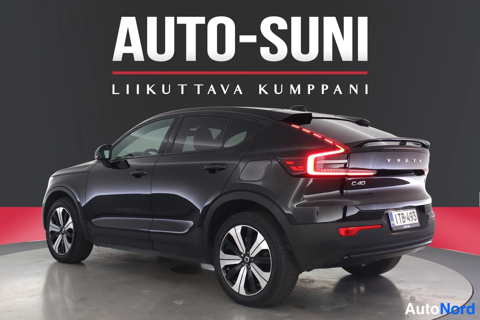 Takaa: Musta Volvo C40 takaviistossa toisesta kulmasta studio­lavatustuksessa. C40­merkki ja rekisterikilpi 1TB-493 näkyvät takaluukissa.