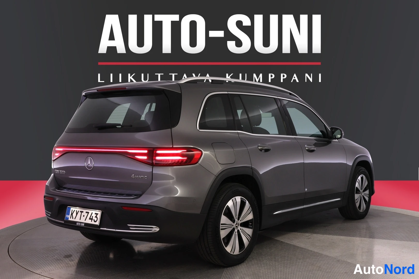 Takaviisto: Mercedes-Benz EQB harmaanäköinen farmurikori, takakolmivuo, rekisteri, takavaloja sytytetty