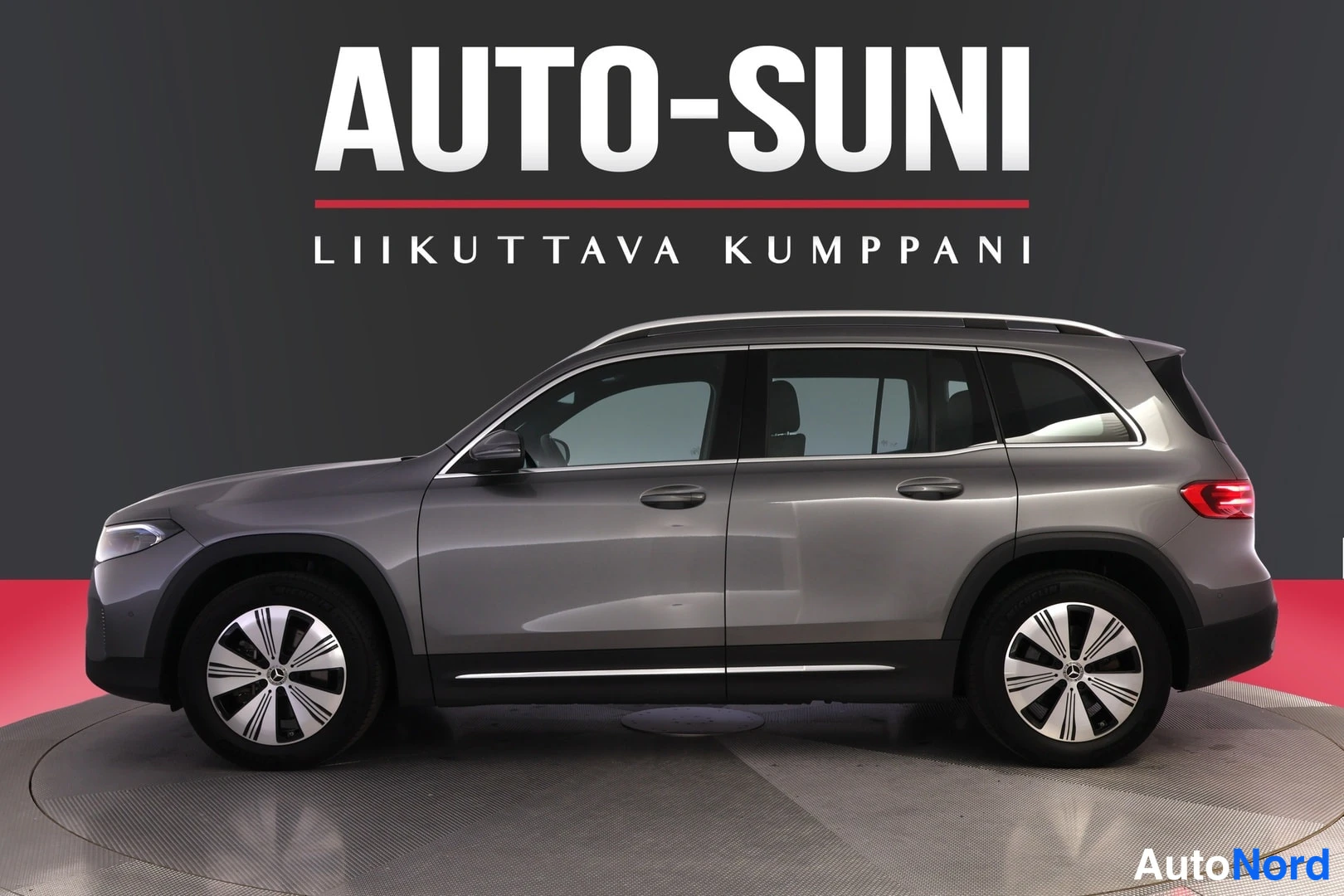 Sivulta: Grey Mercedes-Benz SUV shown in side profile view with alloy wheels and roof rails against a grey background.