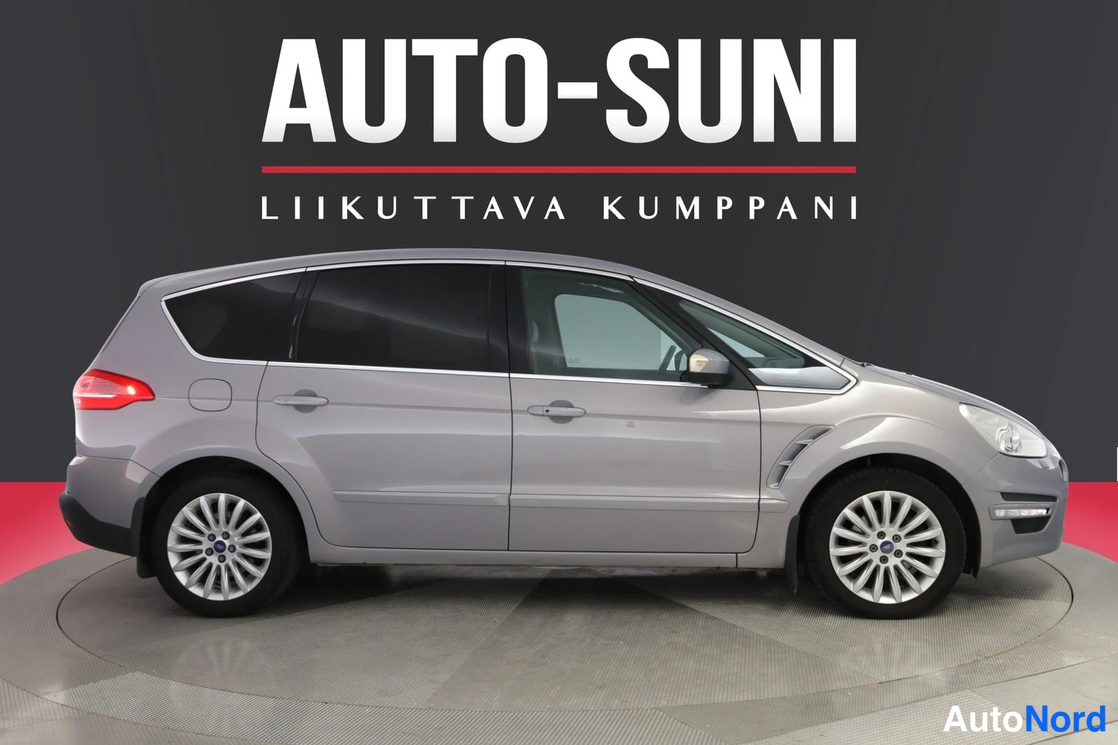 Sivulta: Auton sivuprofiili, harmaa maali, tummat ikkunat.