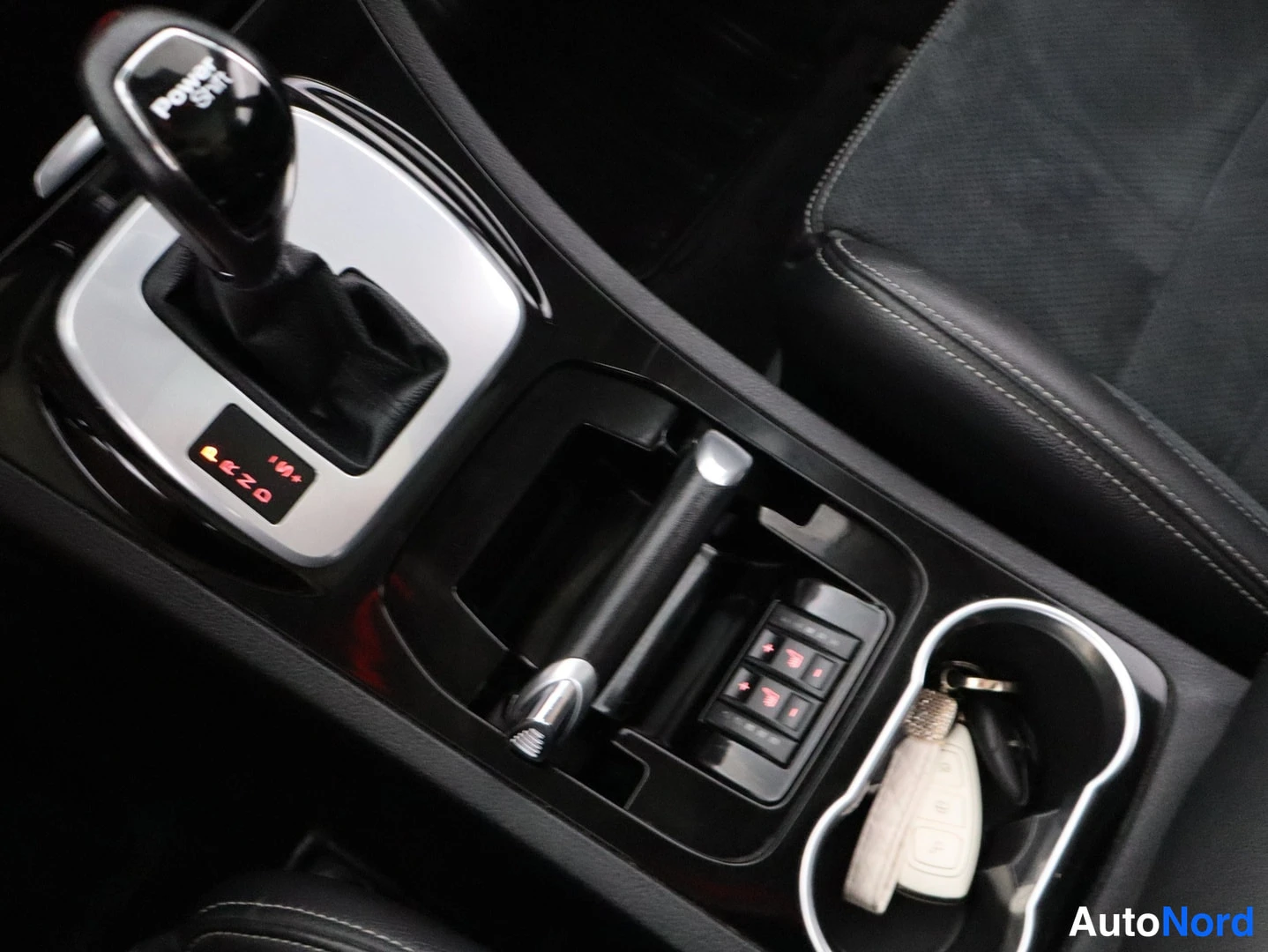 Yksityiskohta: Lähikuva Ford S-MAX 2011 -mallin automaattivaihteiston valitsimesta, istuinlämmitysnäppäimistä ja avaimesta kupitelineessä.