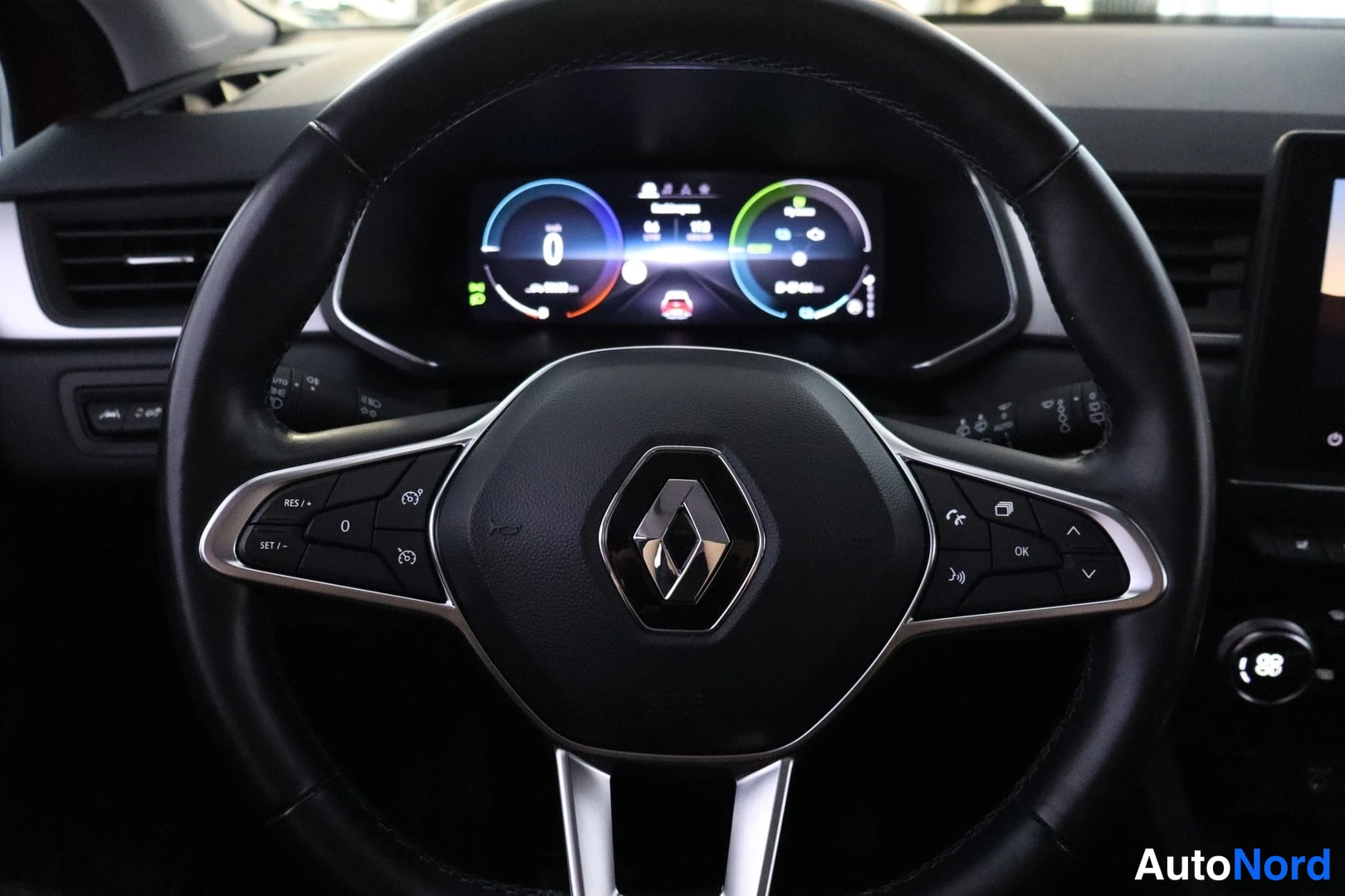 Etuviisto: Renault-logollinen ohjauspyörä monitoiminapeilla, taustalla digitaalinen mittaristo.
