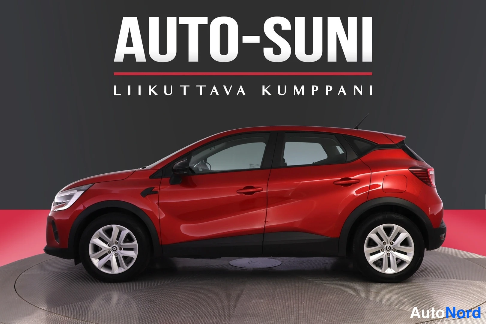 Takaviisto: Punainen henkilöauto sivulta takaa kuvattuna studioseudilla AUTO-SUNI-logolla taustalla.
