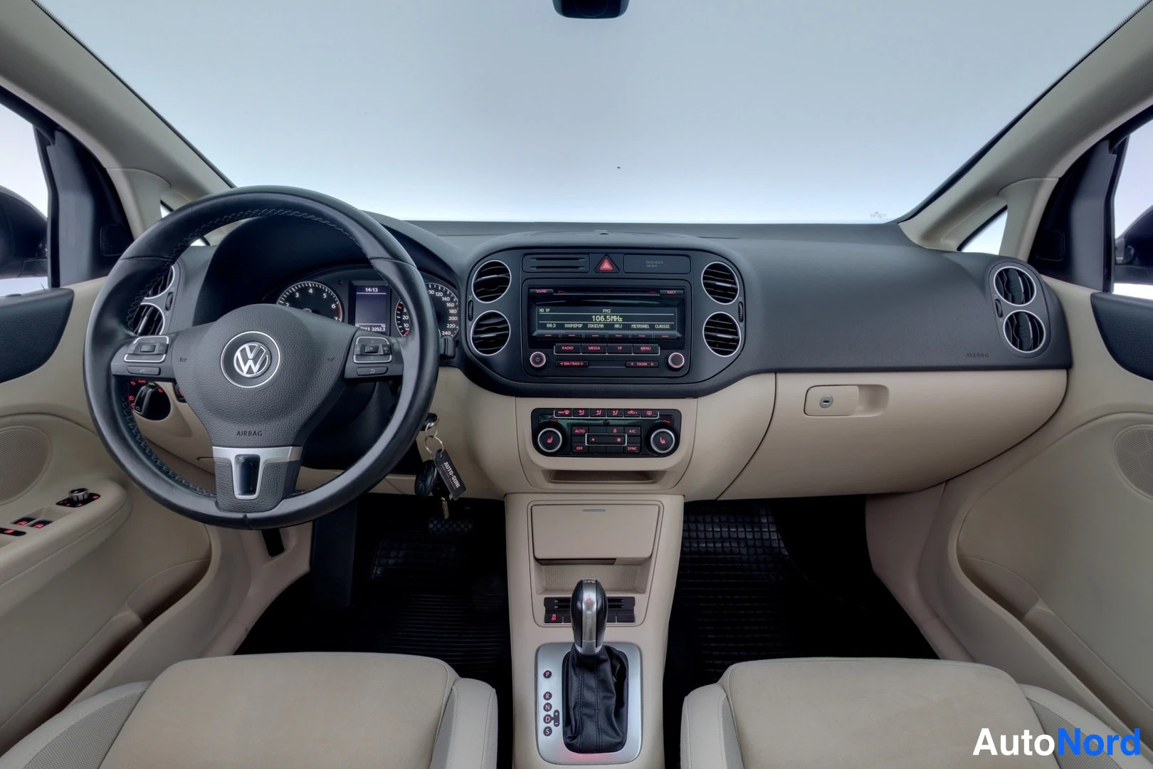 Muu: Ohjaamo eteenpäin: beigestä ja mustasta sisustasta, VW-ohjauspyörä, radio ja automaattivaihteiston valitsin näkyvissä.