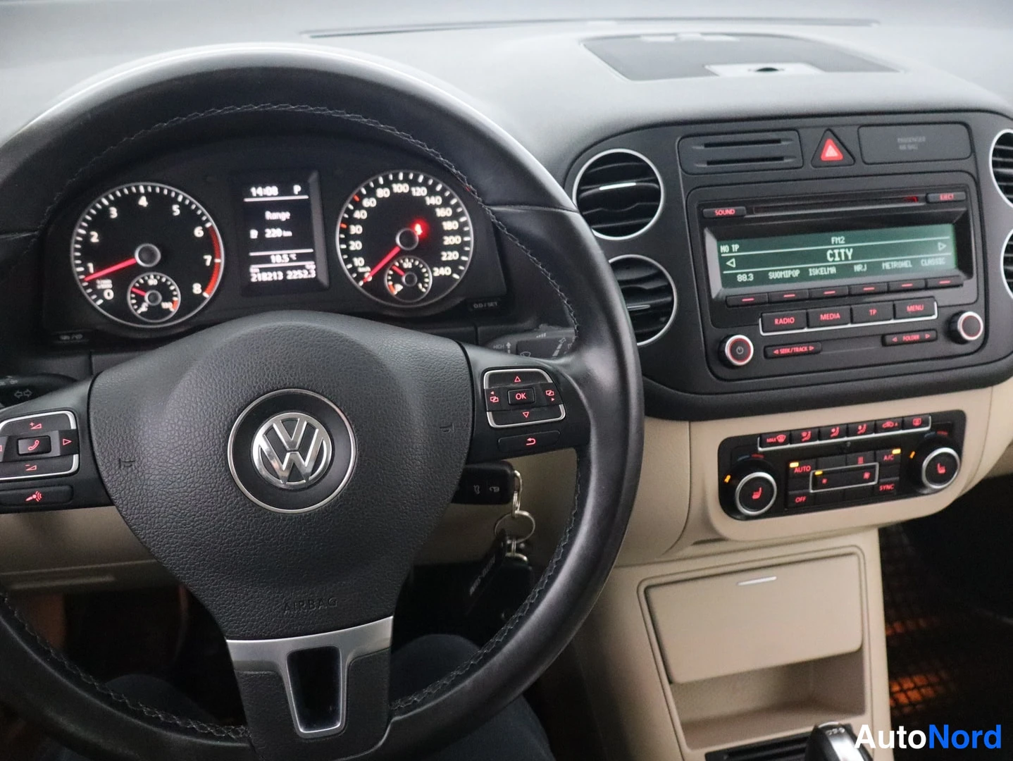 Muu: Volkkari-ohjauspyörä ja mittaristo, keskusnäytöllä 218213 km, sekä radio (CITY, 88.3) ja automaattinen ilmastointi (AUTO).