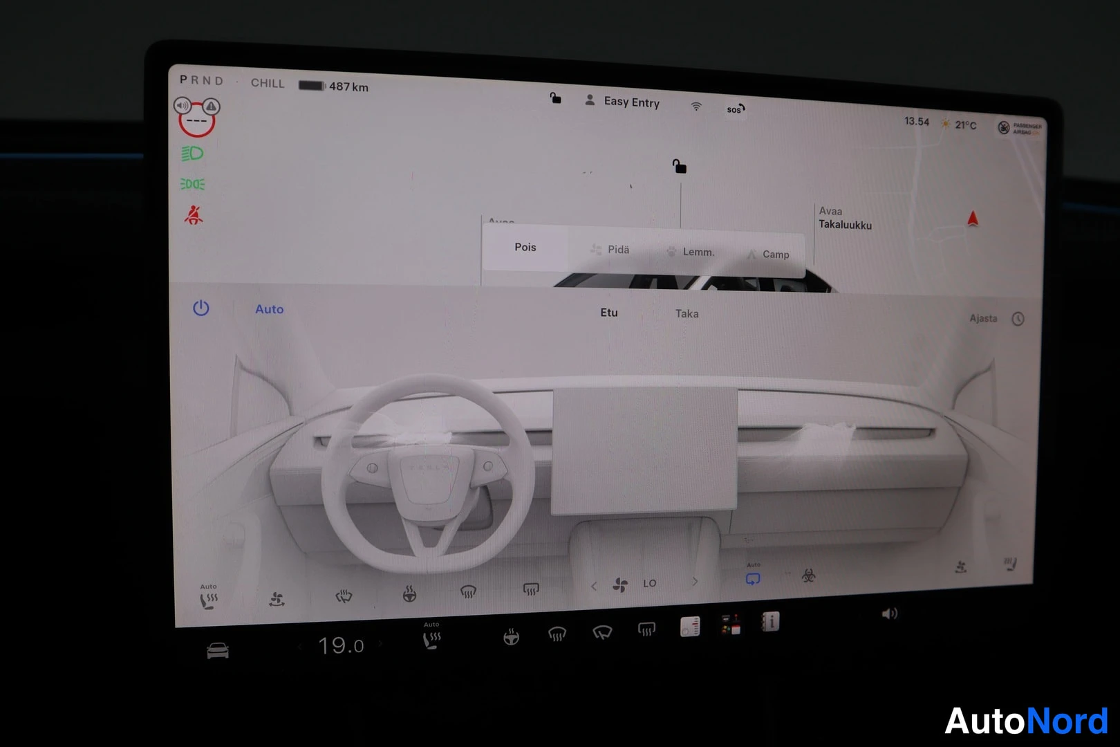 Muu: Tesla Model Y:n näytön ilmastointinäkymä etuistuimille, valikolla Pois, Pida, Lemm. ja Camp. Kuvassa ohjauspyörä ja kojelauta ruudulla.