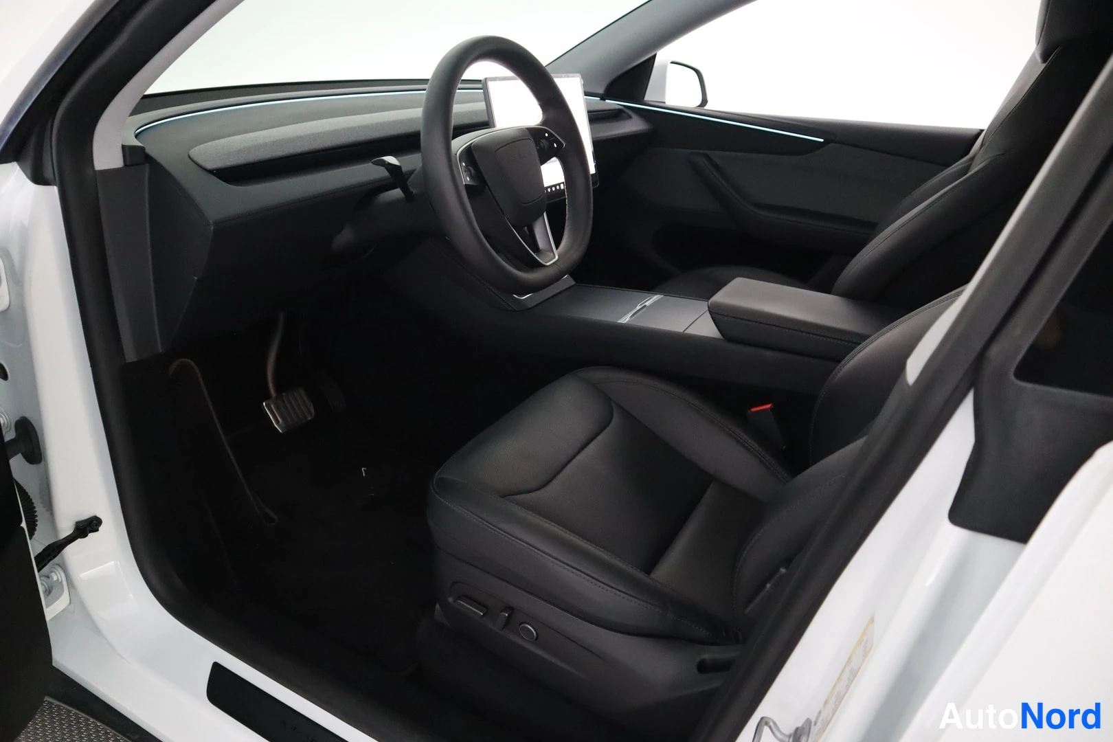 Muu: Auton etuistuin ja ohjaamo valkoisesta autosta kuvattuna ulkopuolelta.