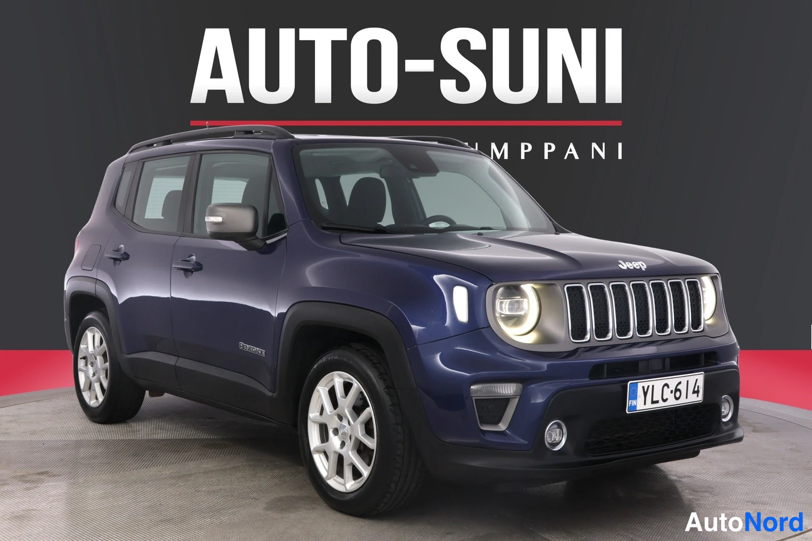 Etuviisto, nokka oikealle: Sininen Jeep Renegade neljästä kolmanneksesta edestä oikealta, rekisteritunnus näkyvissä etupuskurissa.