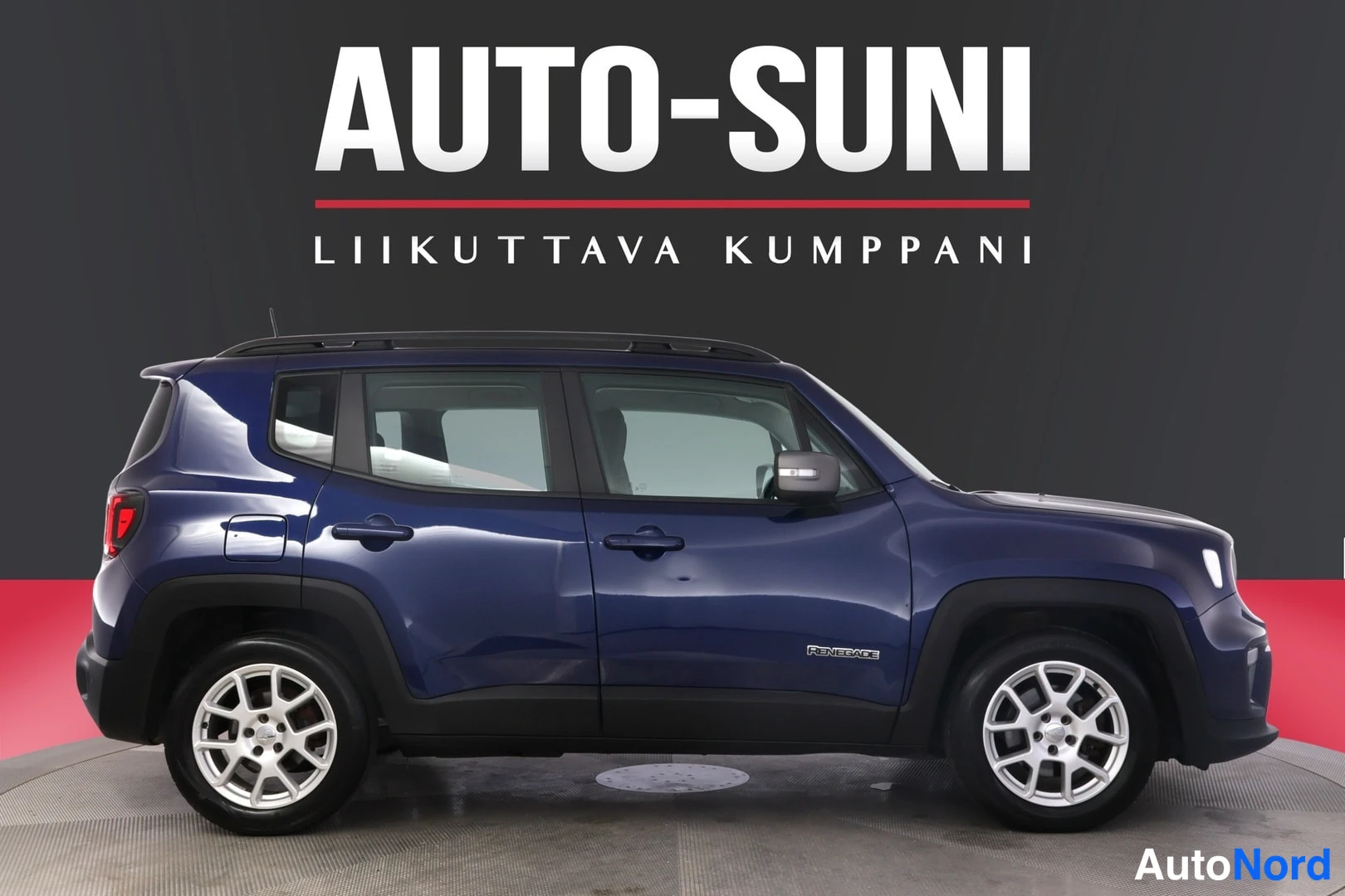 Sivulta: Sininen Jeep Renegade sivulta vasemmalta katsottuna, kattokaiteet ja Renegade-merkintä näkyvissä.