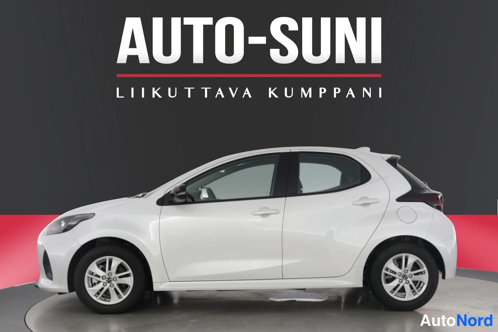 Sivulta: Valkoinen viisiovinen hatchback sivulta kuvattuna studiotytttaustaa vasten.