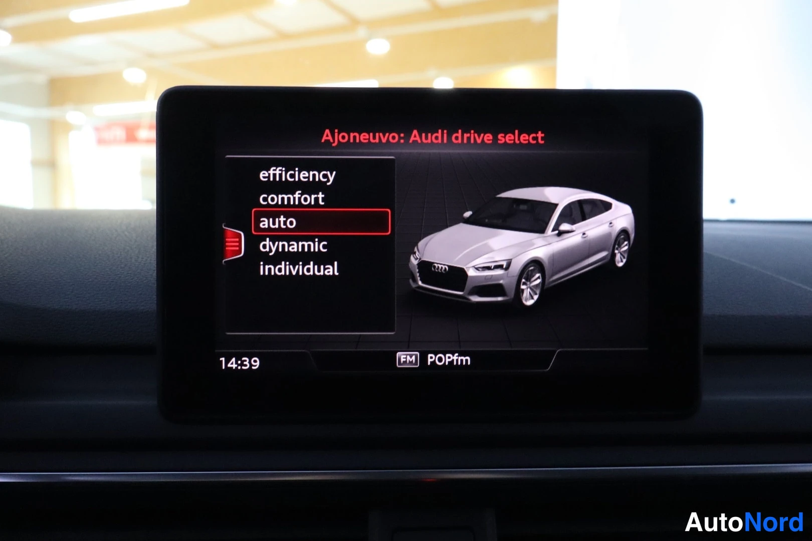Yksityiskohta: Kojelaudan näyttö näyttää Audi drive select -valikon vaihtoehdot efficiency, comfort, auto, dynamic ja individual; auto on valittuna.