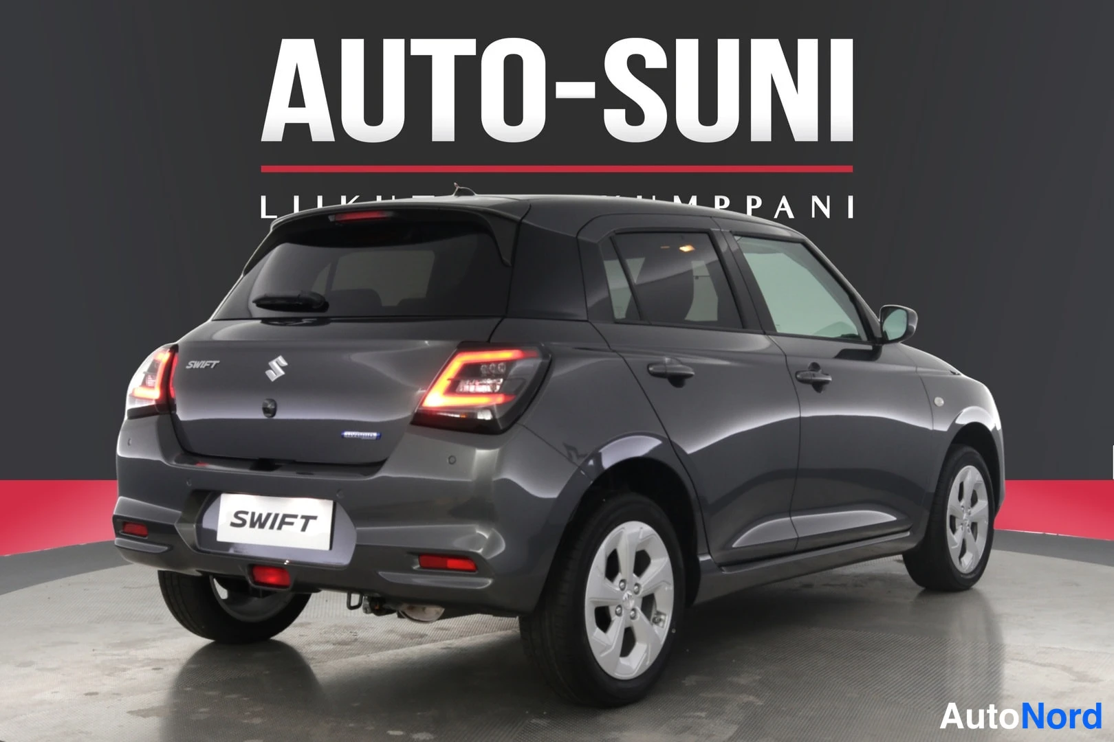 Takaviisto: Harmaan Suzuki Swiftin takaosa ja oikea sivu näkyvät kuvassa.