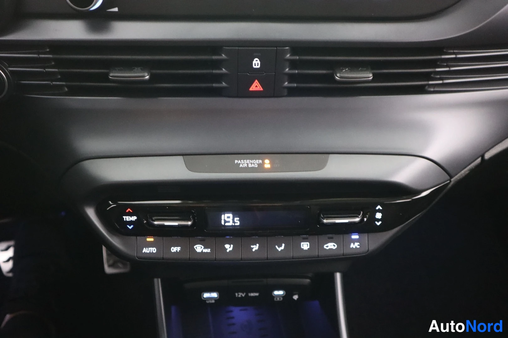 Muu: Auton kojelaudan keskusta: ilmastointipaneeli, jonka näytössä lukema 19,5, ja painikkeet AUTO, OFF ja A/C.