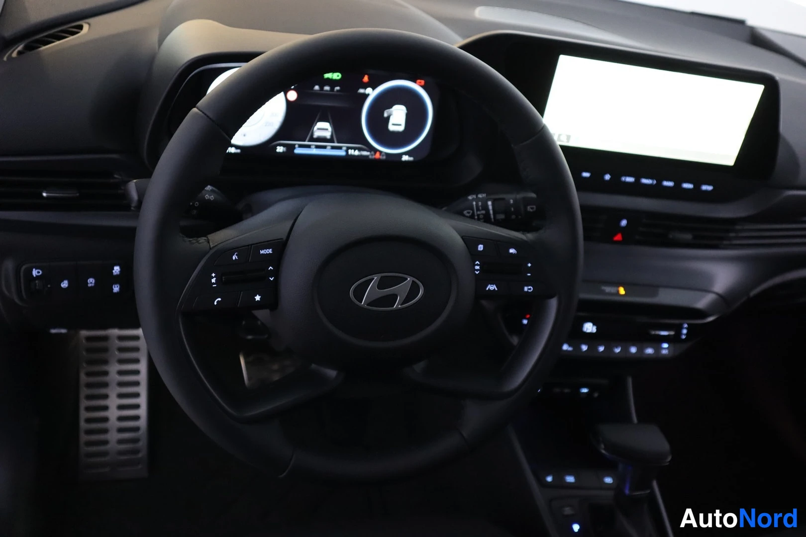 Muu: Ohjauspyörä Hyundai-logolla ja digitaalinen mittaristo sekä keskellä infotainment-näyttö, auton sisätilat.