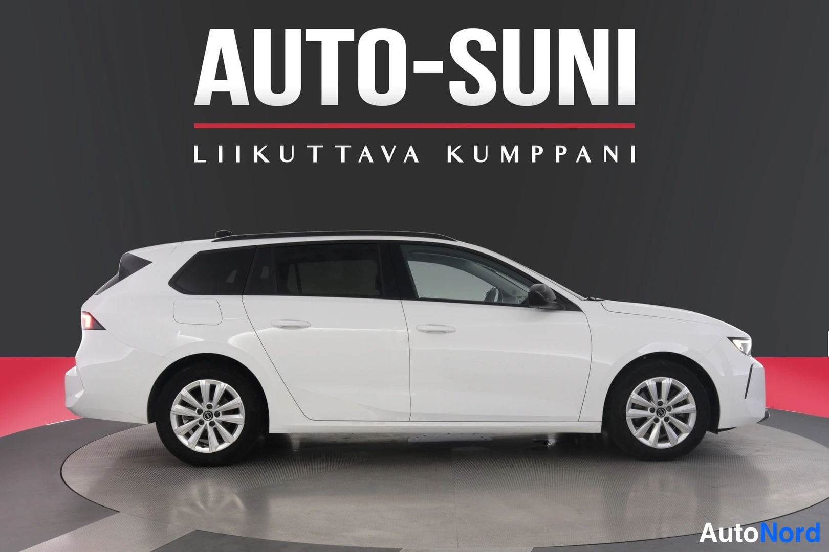 Etuviisto, nokka oikealle: Opel Astra Sports Tourer -farmari valkoisena sivulta oikeaan viistoon, nokka oikeassa reunassa.