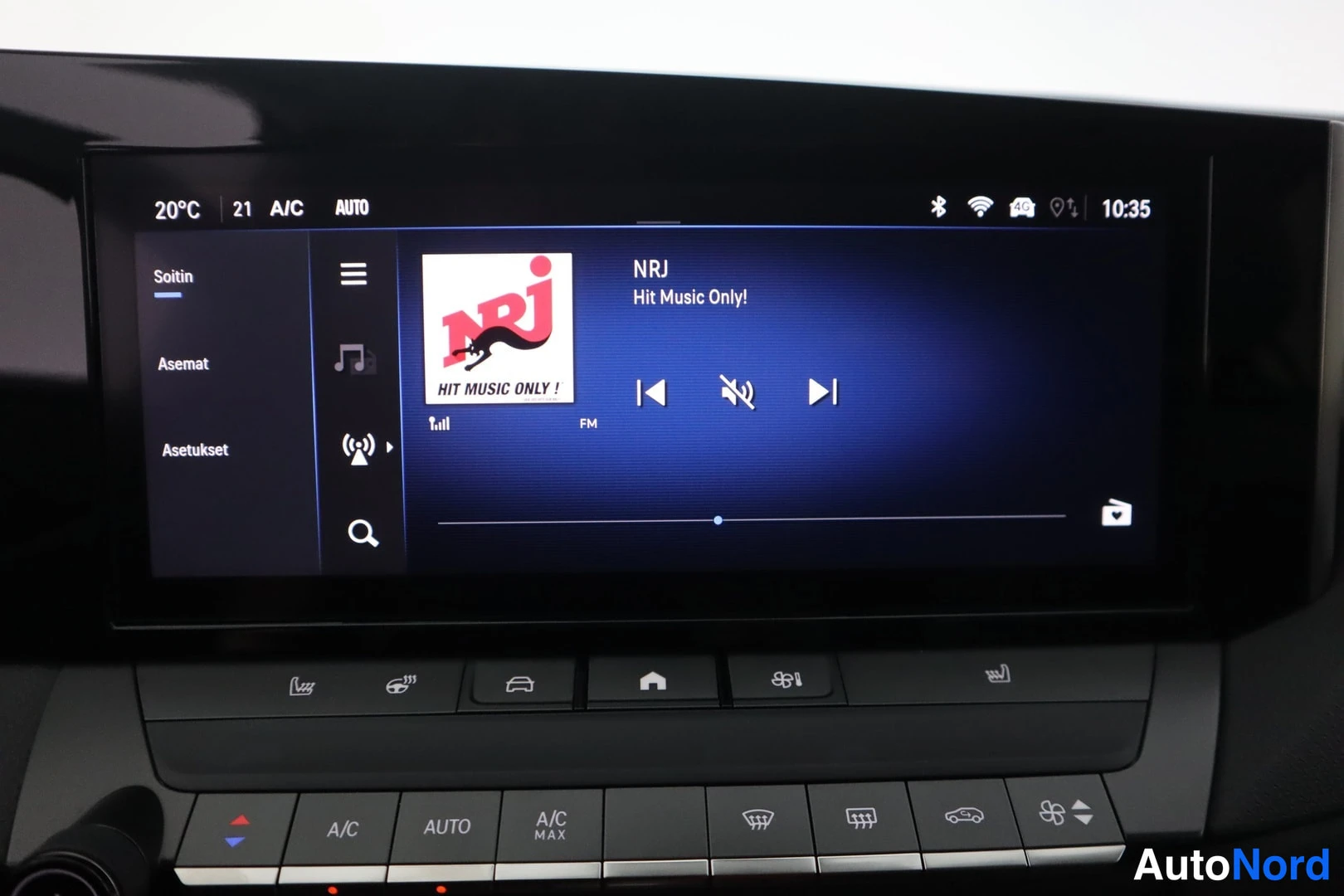 Muu: Kosketusnäytön soitin näyttää NRJ-radiokanavan tekstillä 'Hit Music Only!', A/C- ja AUTO-painikkeet näytön alla.