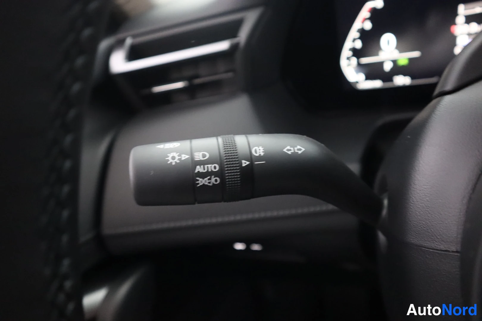 Muu: Sisätilakuva auton hallintakeinosta: valokatkaisijan vivut, joissa tekstit AUTO ja muut merkit.