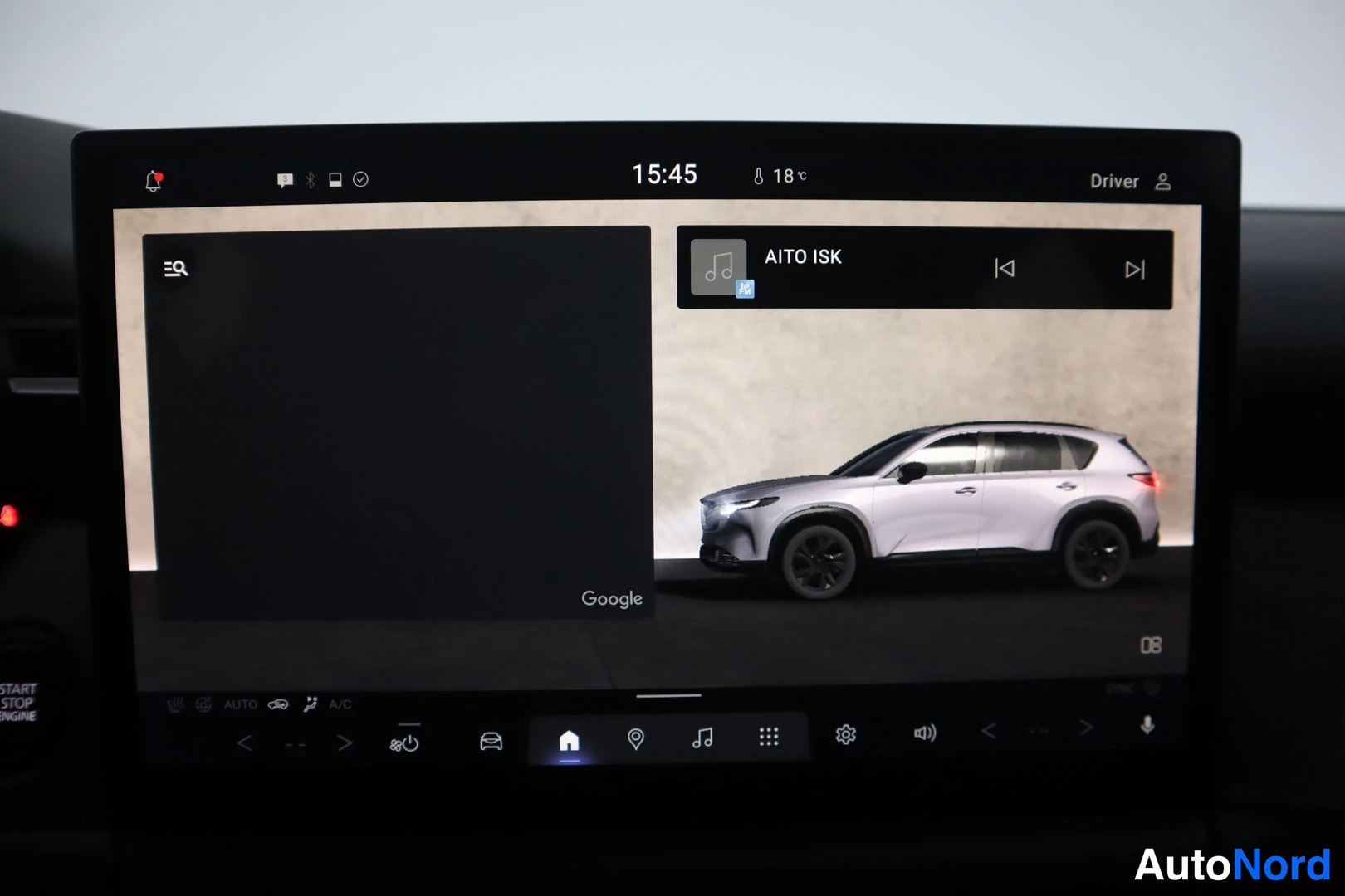 Muu: Auton kojelaudan infotainment-näyttö, jossa näkyy Google-käyttöliittymä ja radiosoitin, kanavana AITO ISK, kellonaika 15:45 ja lämpötila 18 °C.